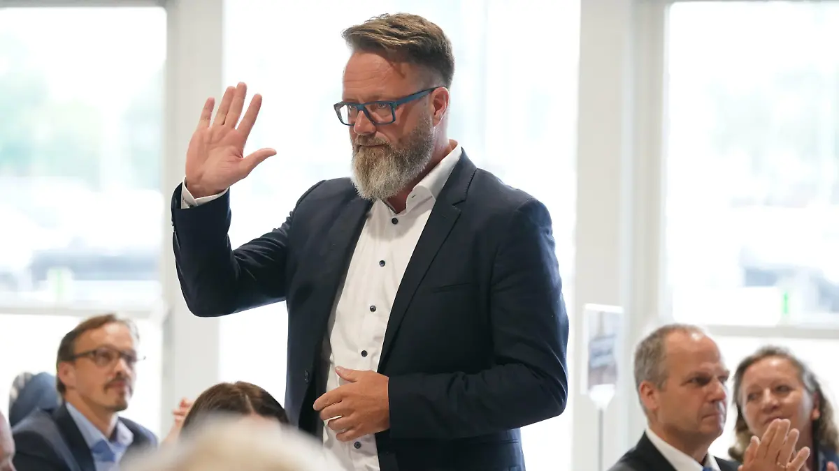 27.06.2022, Schleswig-Holstein, Neumünster: Claus Ruhe Madsen (parteilos), bisheriger Oberbürgermeister der Hansestadt Rostock und zukünftiger Minister für Wirtschaft, Verkehr, Arbeit, Technologie und Tourismus in Schleswig-Holstein, winkt nach seiner Vorstellung den Delegierten auf dem Landesparteitag der CDU zum Abschluss der Koalitionsverhandlungen in den Holstenhallen zu. Foto: Marcus Brandt/dpa +++ dpa-Bildfunk +++