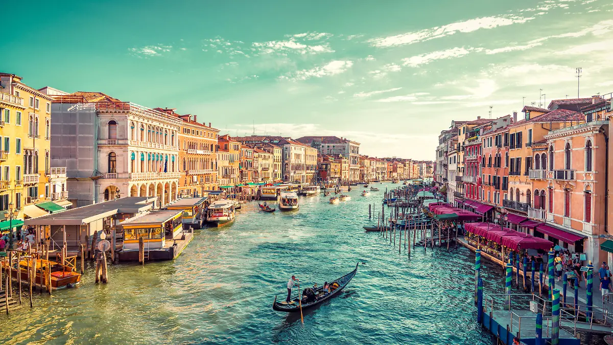 A gondolier paddles towards the sunset in Venice's Grand Canal. Photo taken from the famous Rialto Bridge