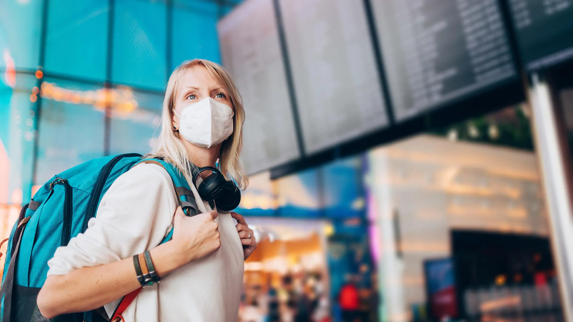Portrait of a young woman checks the arrivals and departures board at the airport. She wears a face mask for protection during a Coronavirus pandemic.
New normal lifestyle for public transport after Covid-19