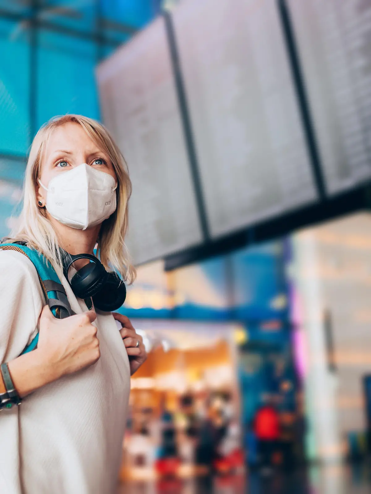 Portrait of a young woman checks the arrivals and departures board at the airport. She wears a face mask for protection during a Coronavirus pandemic.
New normal lifestyle for public transport after Covid-19