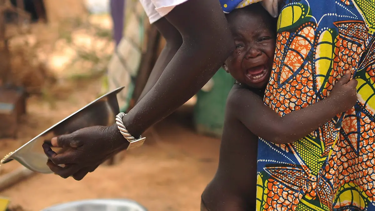 ARCHIV - A picture made available on 19 July 2012 shows a young boy cries as he holds onto his mother on the terrain of a refugees camp near Dori, Burkina Faso, on 04 July 2012. According to reports, over 370,000 people have been displaced by the violence in Mali and continue to cross the borders into the hunger-stricken Burkina Faso and Niger. Photo: EPA/HELMUT FOHRINGER (zu dpa Korr-bericht "Flüchtlingskrisen in Afrika: 15 Millionen auf der Flucht" vom 03.08.2015) +++(c) dpa - Bildfunk+++
