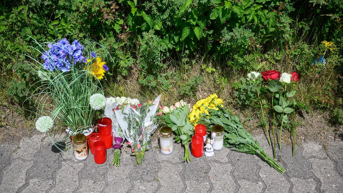 22.06.2022, Niedersachsen, Salzgitter: Kerzen, Blumen und Figuren zum Gedenken an eine getötete 15-jährige liegen an einem Tatort an einer Grünfläche am Hans-Böckler-Ring. Nach dem Fund einer toten 15-Jährigen in Salzgitter gelten zwei Jugendliche als dringend tatverdächtig. Es handele sich um einen 13-Jährigen und einen 14-Jährigen, teilte die Staatsanwaltschaft Braunschweig am Mittwoch mit. Foto: Julian Stratenschulte/dpa +++ dpa-Bildfunk +++