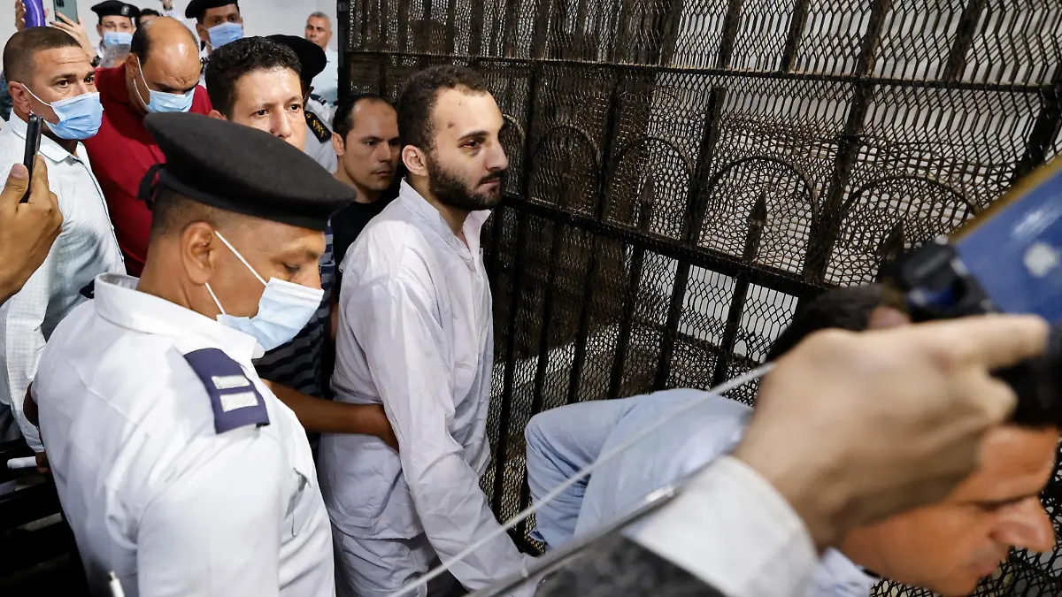 Egyptian Mohamed Adel (C), the presumed murderer of university of Mansoura student Naira Ashraf, is surrounded by guards during as he is taken out of the defender's box, after his first trial session at the Mansoura courthouse, some 145km north of the capital Cairo, on June 26, 2022. (Photo by Khaled DESOUKI / AFP) (Photo by KHALED DESOUKI/AFP via Getty Images)