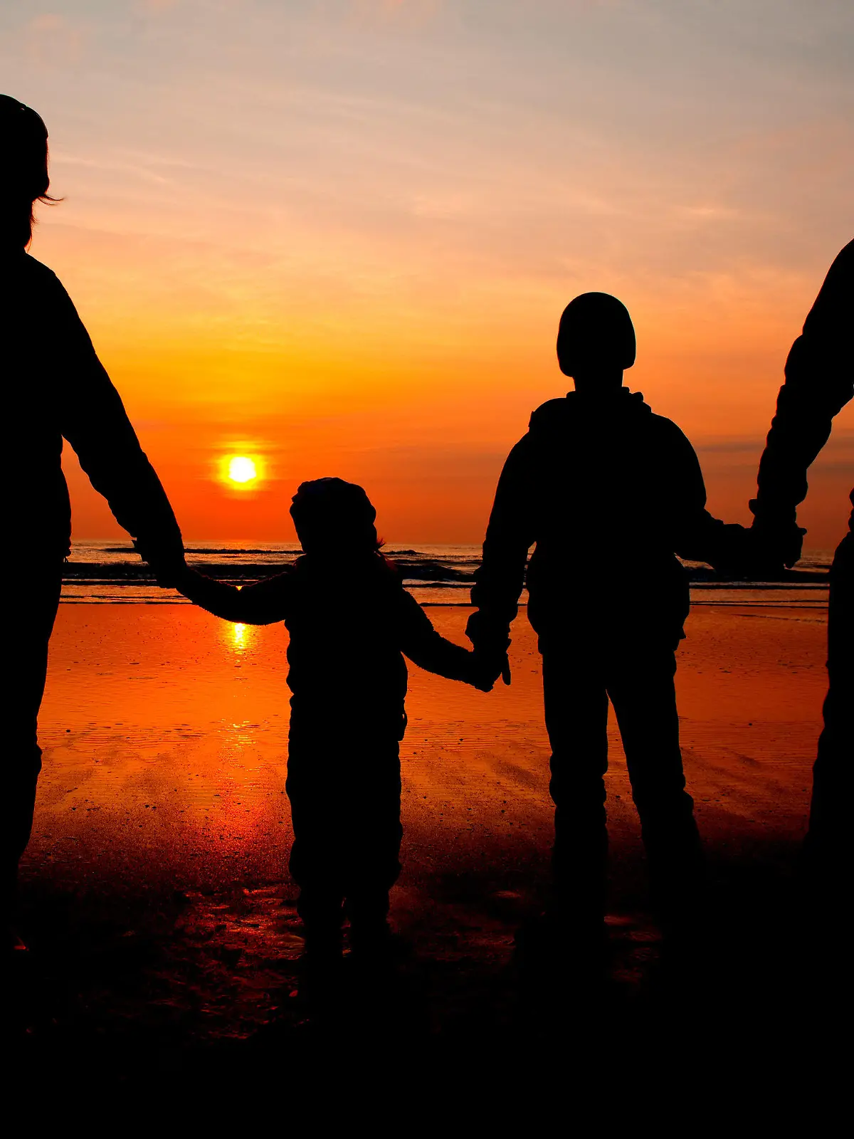 ARCHIV - ILLUSTRATION - Eine Familie schaut sich am 06.04.2010 am Nordseestrand auf der dänischen Insel Romo den Sonnenuntergang an. Foto: Patrick Pleul/dpa  (zu dpa-Korr "F wie Familienleben - Patchwork und Armut nehmen zu" vom 14.05.2015) +++(c) dpa - Bildfunk+++