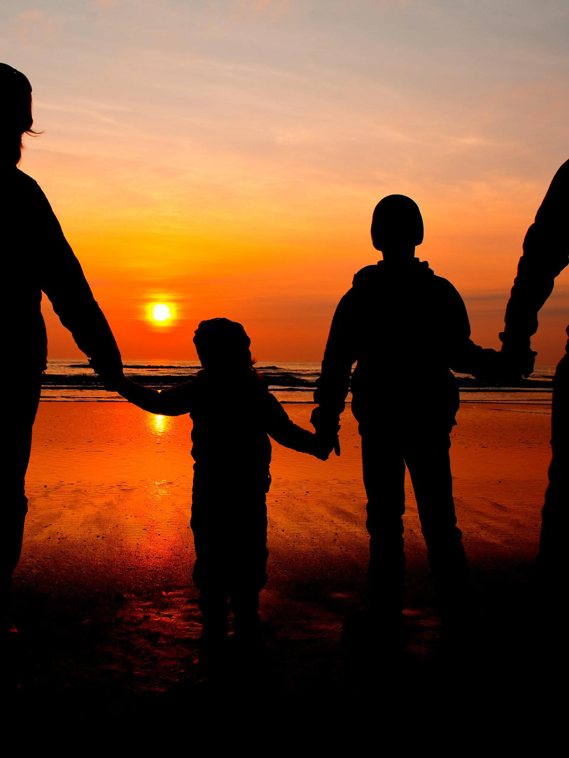 ARCHIV - ILLUSTRATION - Eine Familie schaut sich am 06.04.2010 am Nordseestrand auf der dänischen Insel Romo den Sonnenuntergang an. Foto: Patrick Pleul/dpa  (zu dpa-Korr "F wie Familienleben - Patchwork und Armut nehmen zu" vom 14.05.2015) +++(c) dpa - Bildfunk+++