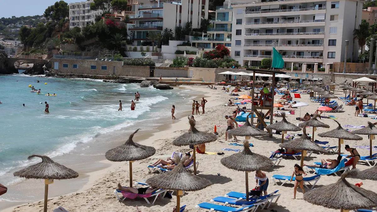 12.08.2020, Spanien, Palma: Menschen sind am Strand Cala Major in Palma. Angesichts steigender Corona-Zahlen geht auch auf Mallorca und den anderen Balearen-Inseln die Angst um, zu einem Corona-Risikogebiet erklärt zu werden. Foto: Clara Margais/dpa +++ dpa-Bildfunk +++