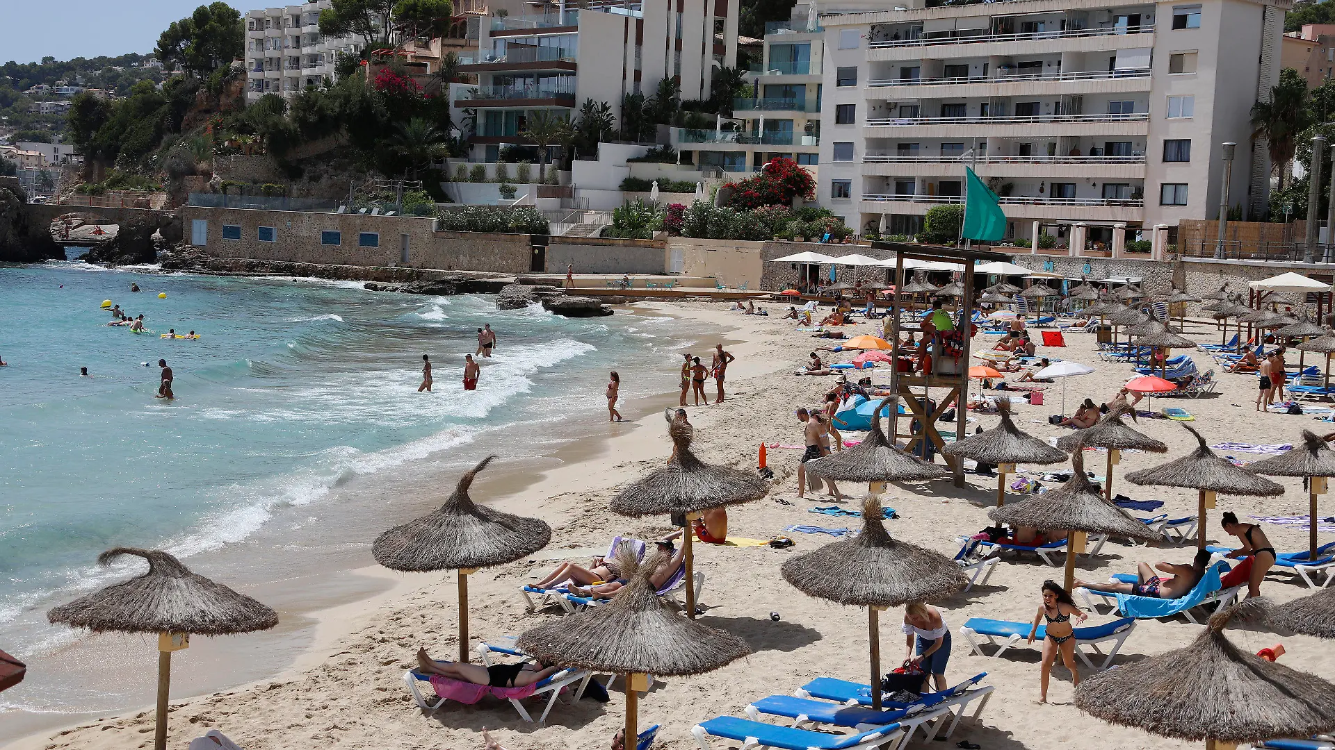 12.08.2020, Spanien, Palma: Menschen sind am Strand Cala Major in Palma. Angesichts steigender Corona-Zahlen geht auch auf Mallorca und den anderen Balearen-Inseln die Angst um, zu einem Corona-Risikogebiet erklärt zu werden. Foto: Clara Margais/dpa +++ dpa-Bildfunk +++