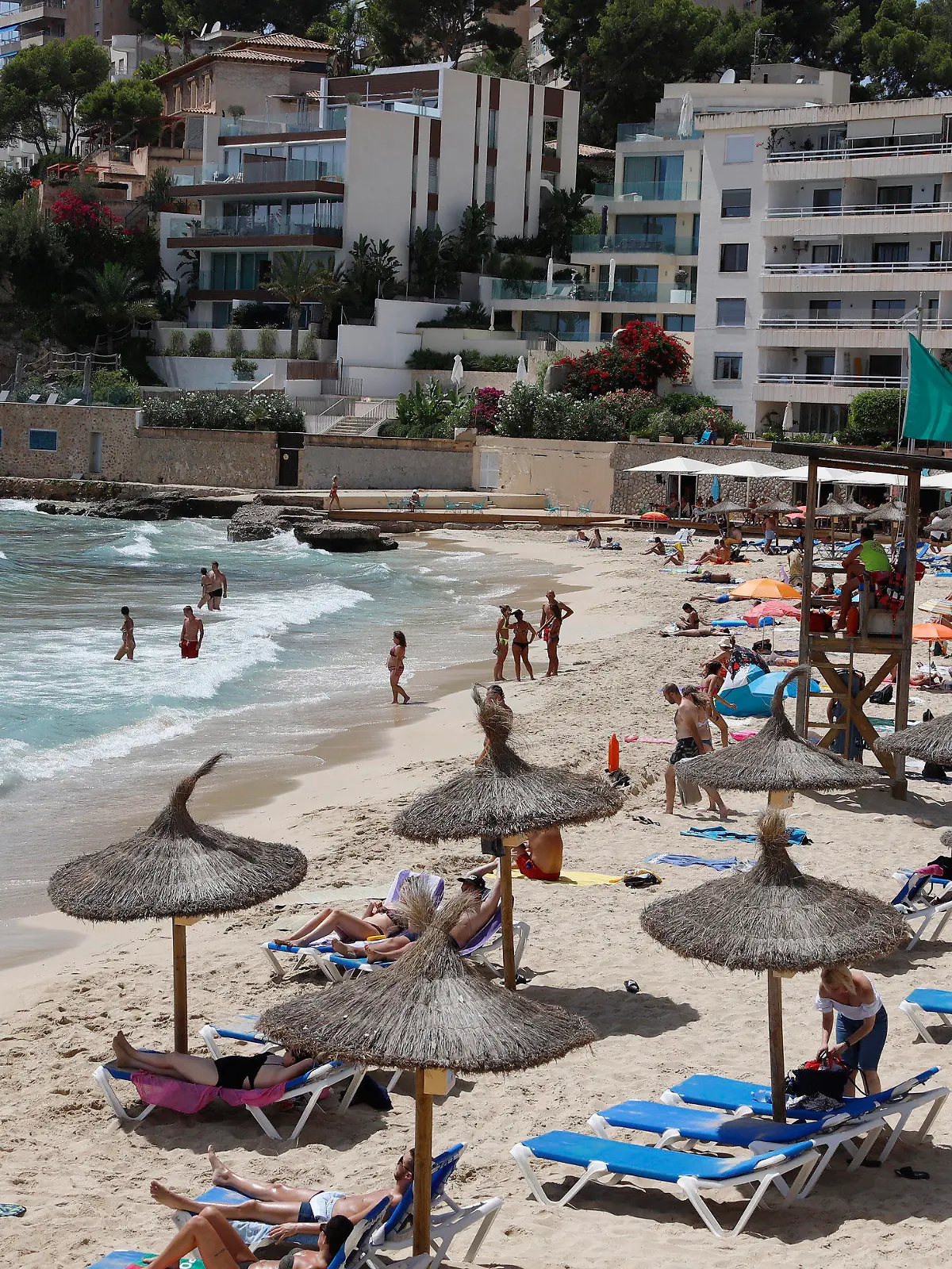 12.08.2020, Spanien, Palma: Menschen sind am Strand Cala Major in Palma. Angesichts steigender Corona-Zahlen geht auch auf Mallorca und den anderen Balearen-Inseln die Angst um, zu einem Corona-Risikogebiet erklärt zu werden. Foto: Clara Margais/dpa +++ dpa-Bildfunk +++