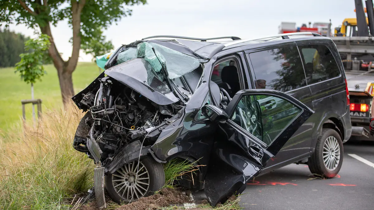 26.06.2022, Lauterbach: Ein zerstörter Van wird nach einem Unfall geborgen. Bei einem schweren Verkehrsunfall in Lauterbach (Vogelsbergkreis) sind eine 37 Jahre alte Beifahrerin tödlich und drei weitere Menschen, darunter zwei Kinder, schwer verletzt worden. Nach ersten Erkenntnissen kam die Familie mit ihrem Van in einer Senke im Kurvenbereich von der Straße ab und prallte gegen einen Baum, wie die Polizei mitteilte. Der Grund für den Unfall war zunächst unklar. Der Vater, der den Wagen fuhr, wurde ebenfalls schwer verletzt. Foto: Fuldamedia/dpa +++ dpa-Bildfunk +++