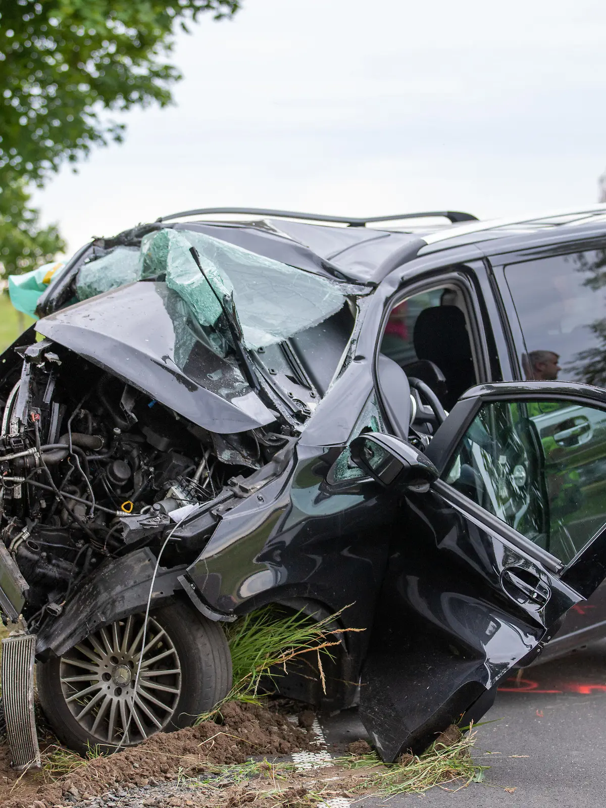 26.06.2022, Lauterbach: Ein zerstörter Van wird nach einem Unfall geborgen. Bei einem schweren Verkehrsunfall in Lauterbach (Vogelsbergkreis) sind eine 37 Jahre alte Beifahrerin tödlich und drei weitere Menschen, darunter zwei Kinder, schwer verletzt worden. Nach ersten Erkenntnissen kam die Familie mit ihrem Van in einer Senke im Kurvenbereich von der Straße ab und prallte gegen einen Baum, wie die Polizei mitteilte. Der Grund für den Unfall war zunächst unklar. Der Vater, der den Wagen fuhr, wurde ebenfalls schwer verletzt. Foto: Fuldamedia/dpa +++ dpa-Bildfunk +++