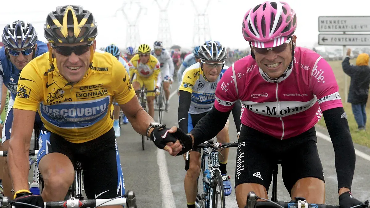 epa000488371 Race leader American Lance Armstrong (L) of Discovery Channel Team holds hands with German Jan Ullrich (R) of T-Mobile Team during the start of the 21st stage of the 2005 Tour de France cycling race, Sunday 24 July 2005 in Corbeil-Essonnes. The 144.5km 21st and last stage of the 92nd Tour de France leads the cyclists from Corbeil-Essonnes to the finish on the Champs-Elysees in Paris. EPA/GERO BRELOER