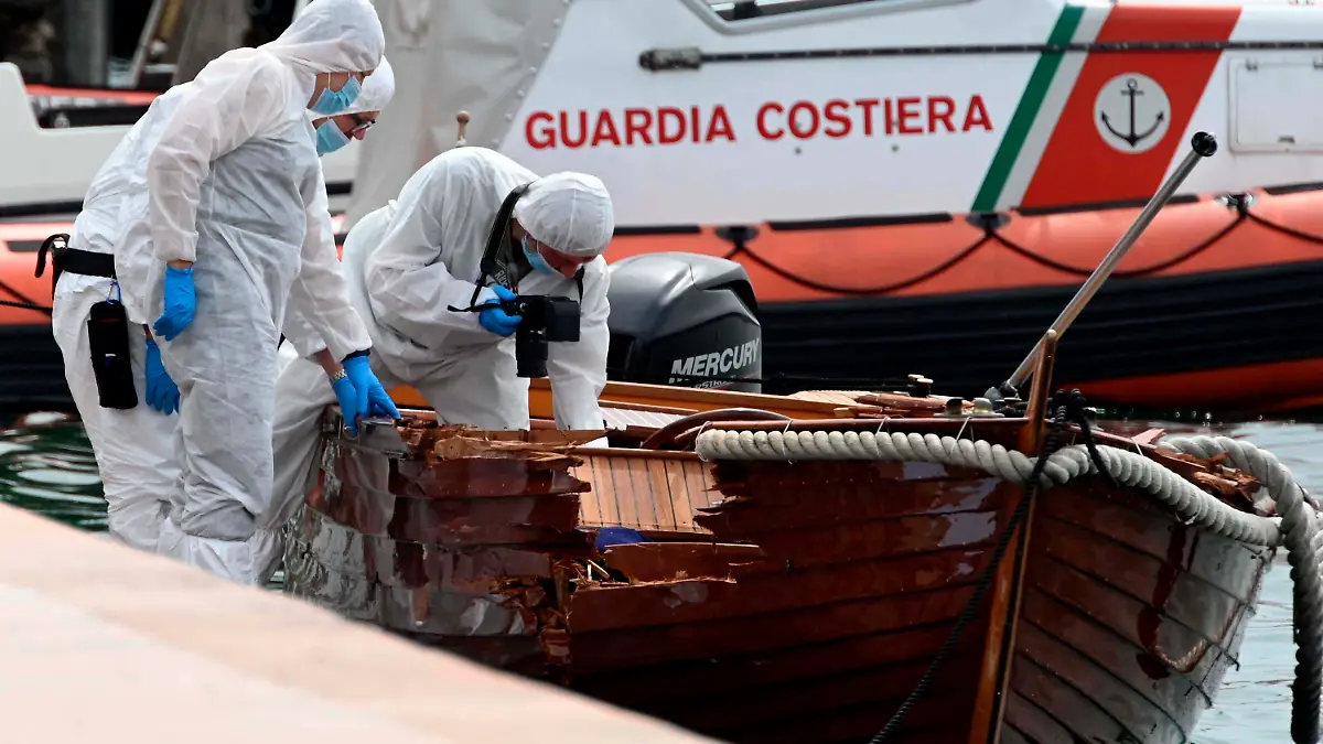 ARCHIV - 20.06.2021, Italien, Salo: Forensiker begutachten den Schaden an einem Boot im Hafen von Salo. Zwei Münchner sollen in einer Nacht im Juni ein Motorboot gesteuert haben, das mit einem kleinen Boot kollidierte. Dabei starben die beiden Insassen des kleinen Bootes. (zu dpa: «Urteilsverkündung im Gardasee-Prozess mit zwei angeklagten Deutschen») Foto: Gabriele Strada/AP/dpa +++ dpa-Bildfunk +++