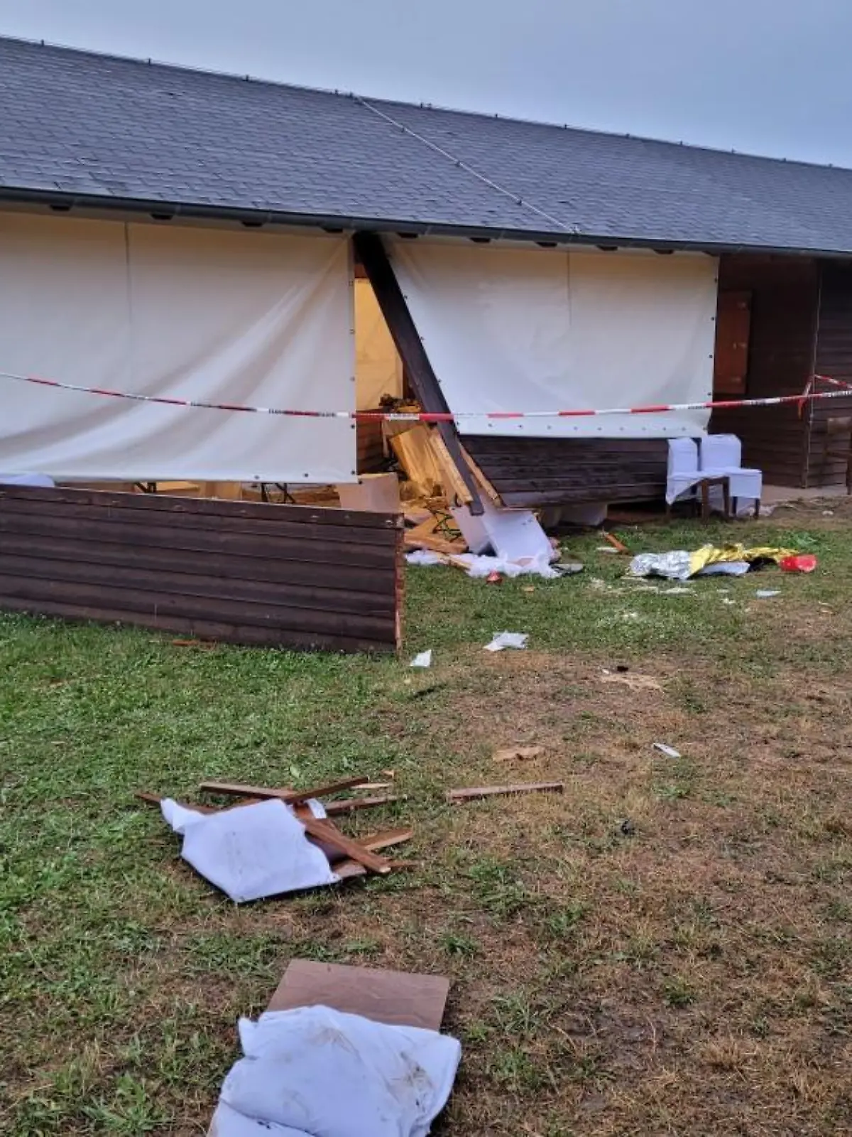 24.06.2022, Hessen, Riedstadt: Trümmer liegen hinter einer Grillhütte. Im südhessischen Riedstadt ist eine Frau mit einem Auto durch eine Hütte mit feiernden Menschen gefahren. Es seien acht Menschen verletzt worden, zwei von ihnen schwer, teilte die Polizei am Freitagabend mit. Foto: 5vision.Media/dpa +++ dpa-Bildfunk +++