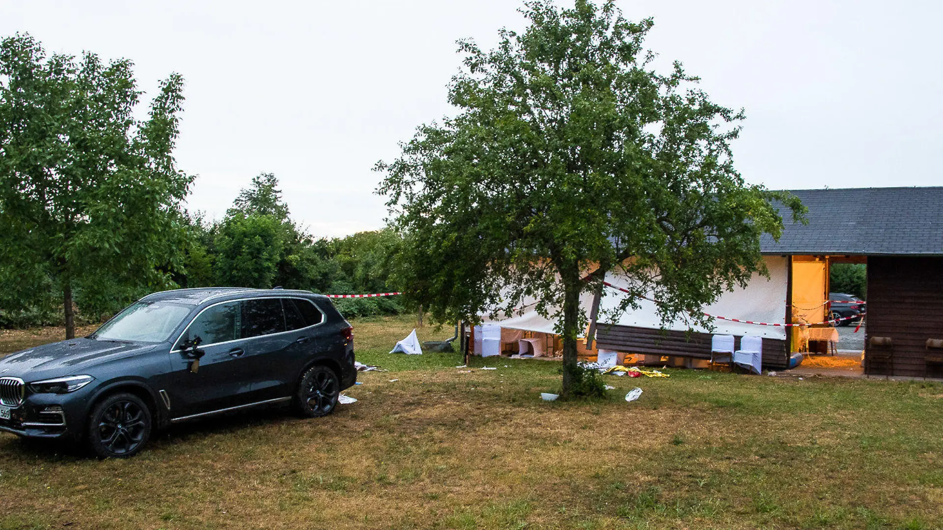 24.06.2022, Hessen, Riedstadt: Ein Auto steht hinter einer Grillhütte. Sieben Menschen bei einer Geburtstagsfeier verletzt worden, weil eine Frau mit ihrem Auto versehentlich durch einen Aufenthaltsbereich für die Gäste bei einer Grillhütte fuhr. Drei Frauen sind bei dem Unfall schwer verletzt worden, zwei davon lebensgefährlich. Foto: 5vision.Media/dpa +++ dpa-Bildfunk +++