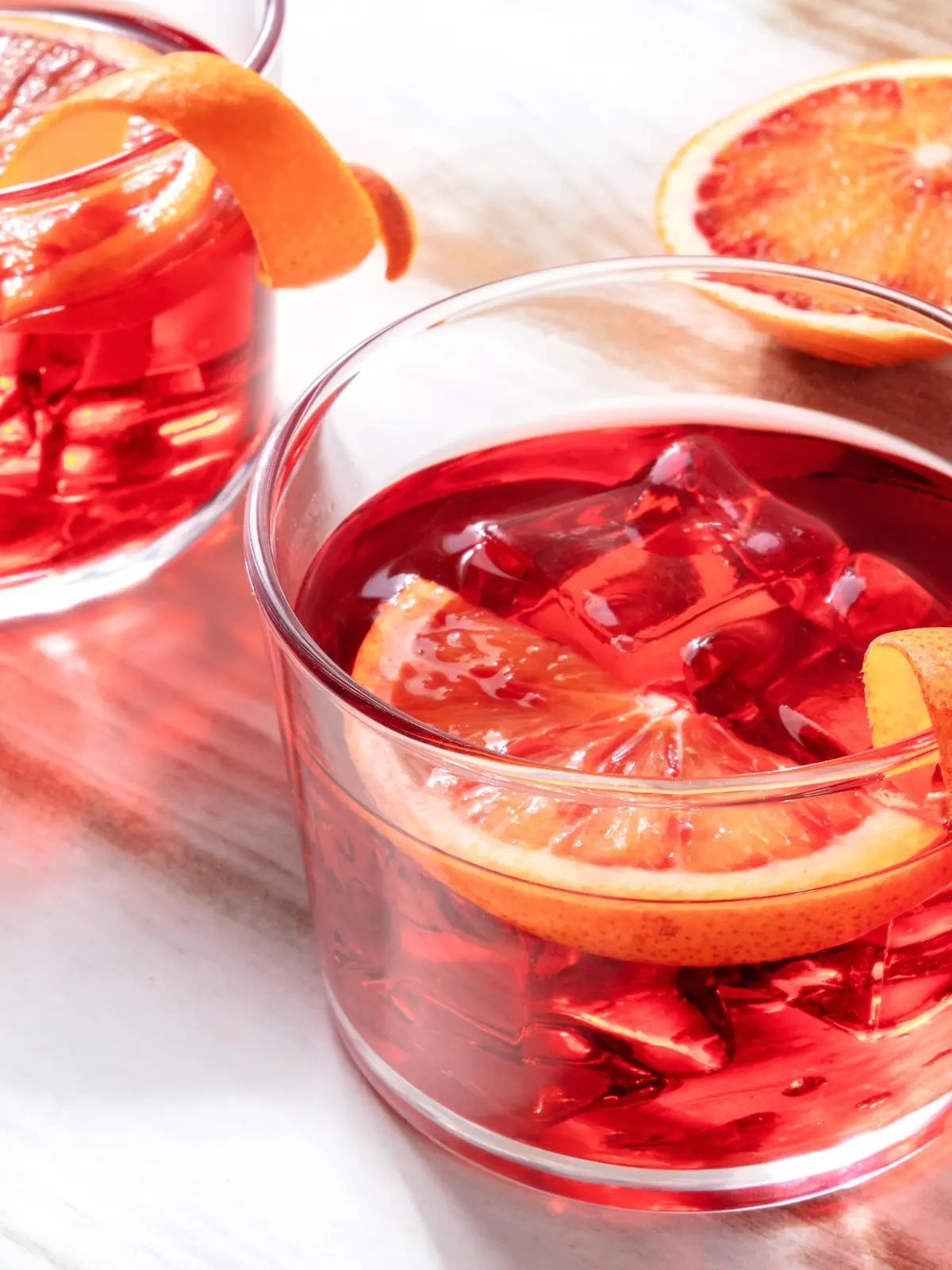 Negroni cocktail with blood oranges, on a wooden background