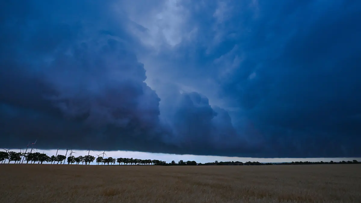 20.06.2022, Brandenburg, Sieversdorf: Am späten Abend zieht eine Gewitterzelle mit dunklen Regenwolken über die Landschaft. Foto: Patrick Pleul/dpa +++ dpa-Bildfunk +++