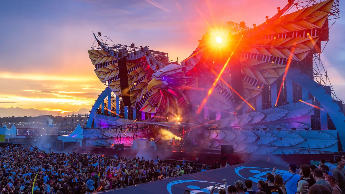 15.07.2023, Mecklenburg-Vorpommern, Neustadt-Glewe: Besucher des Festivals «Airbeat One» tanzen nach Sonnenuntergang vor einer der insgesamt fünf Bühne auf dem Festivalgelände. Das Elektromusik-Festival «Airbeat One» geht am 16.07.2023 auf dem Flugplatz der 7.000 Einwohner zählenden Kleinstadt zu Ende. Täglich waren bis zu 65.000 Feiernde auf dem Gelände erwartet worden. «Airbeat One» ist das zweitgrößte Event in MV nach dem Fusion-Festival. Das Motto der 20. Airbeat One-Ausgabe lautete: «Edition Home Germany». Foto: Jens Büttner/dpa +++ dpa-Bildfunk +++