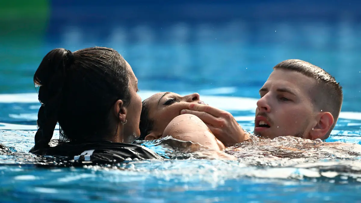 Anita Alvarez of United States, center, is taken from the pool after collapsing during the solo free final of the artistic swimming at the 19th FINA World Championships in Budapest, Hungary, Wednesday, June 22, 2022. (AP Photo/Anna Szilagyi)