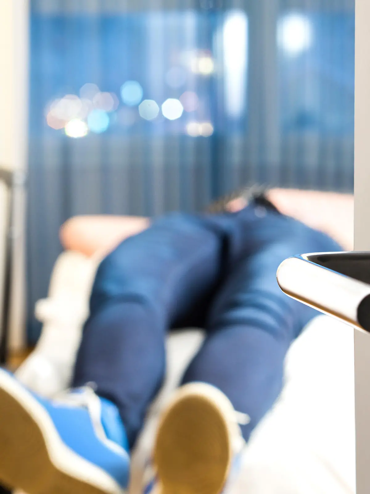 Tired traveler sleeping on hotel room bed. Exhausted man after long flight and travel with baggage. Tourist arrived home from vacation. Lying in bedroom next to suitcase. Sick person after holiday.