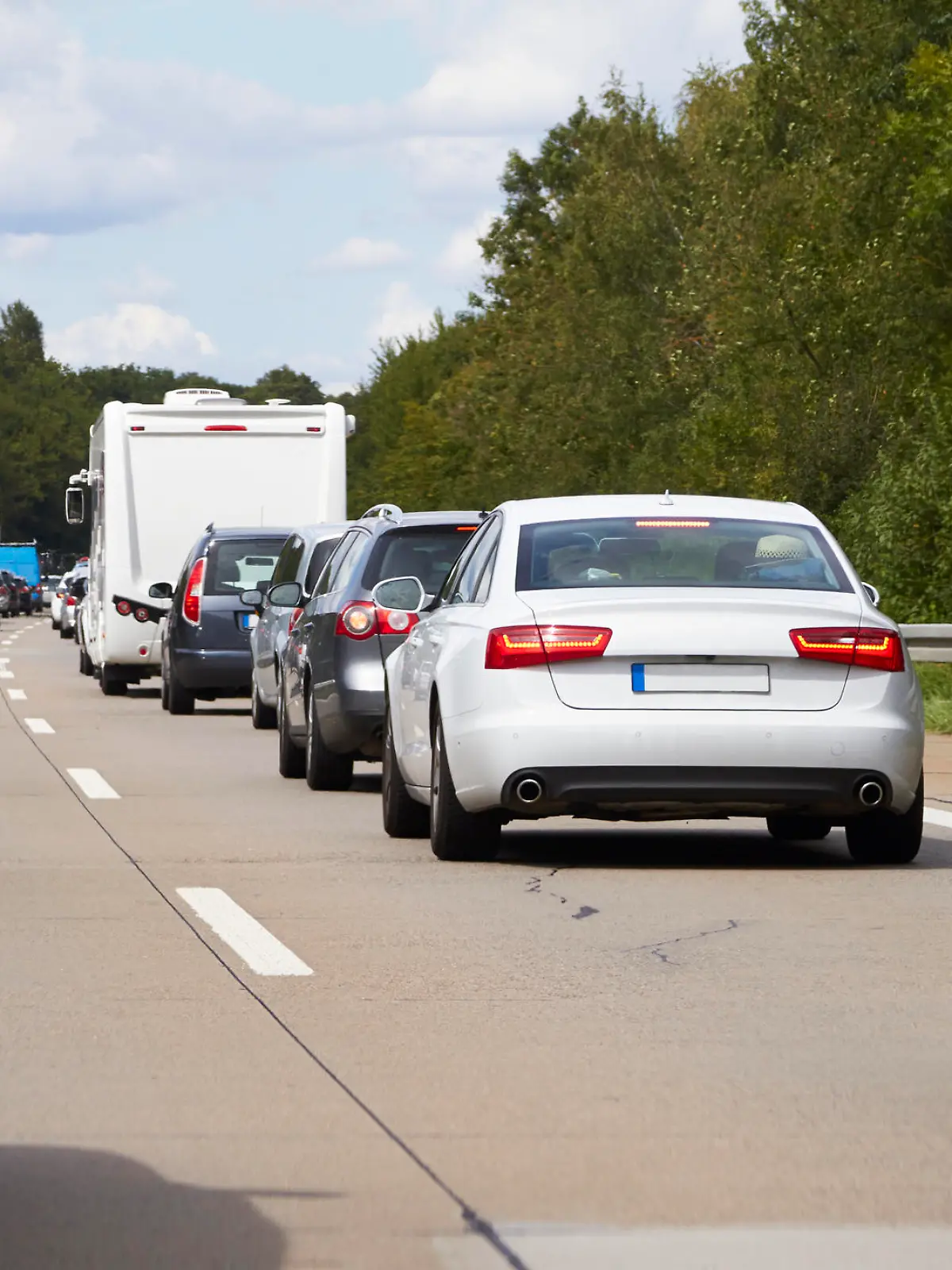 On a summer day cars jam on the highway.