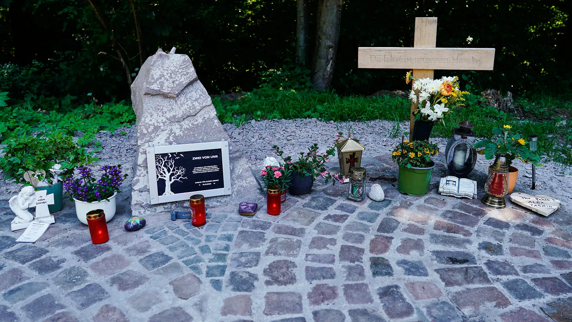 16.06.2022, Rheinland-Pfalz, Kusel: Ein Holzkreuz und Kerzen steht an einer Landstraße zwischen Kusel und Ulmet an einer Gedenkstätte für zwei getötete Polizisten. Der Mordprozess wegen tödlicher Schüsse auf zwei Polizisten bei einer nächtlichen Verkehrskontrolle in der Pfalz beginnt am 21. Juni in Kaiserslautern. (zu dpa: "Ex-Polizist gestaltet Gedenkort für erschossene Kollegen in der Pfalz") Foto: Uwe Anspach/dpa +++ dpa-Bildfunk +++