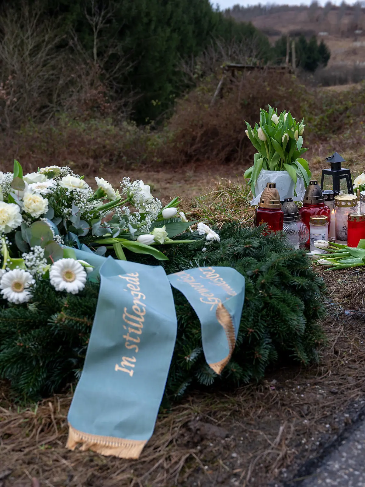 02.02.2022, Rheinland-Pfalz, Kusel: Ein Kranz sowie Blumen und Kerzen liegen am Tatort an der Kreisstraße 22 bei Ulmet (Rheinland-Pfalz) zum Gedenken. Am Montag wurden in der Nähe bei Ulmet eine Polizistin und ein Polizist im Dienst getötet. Foto: Harald Tittel/dpa +++ dpa-Bildfunk +++