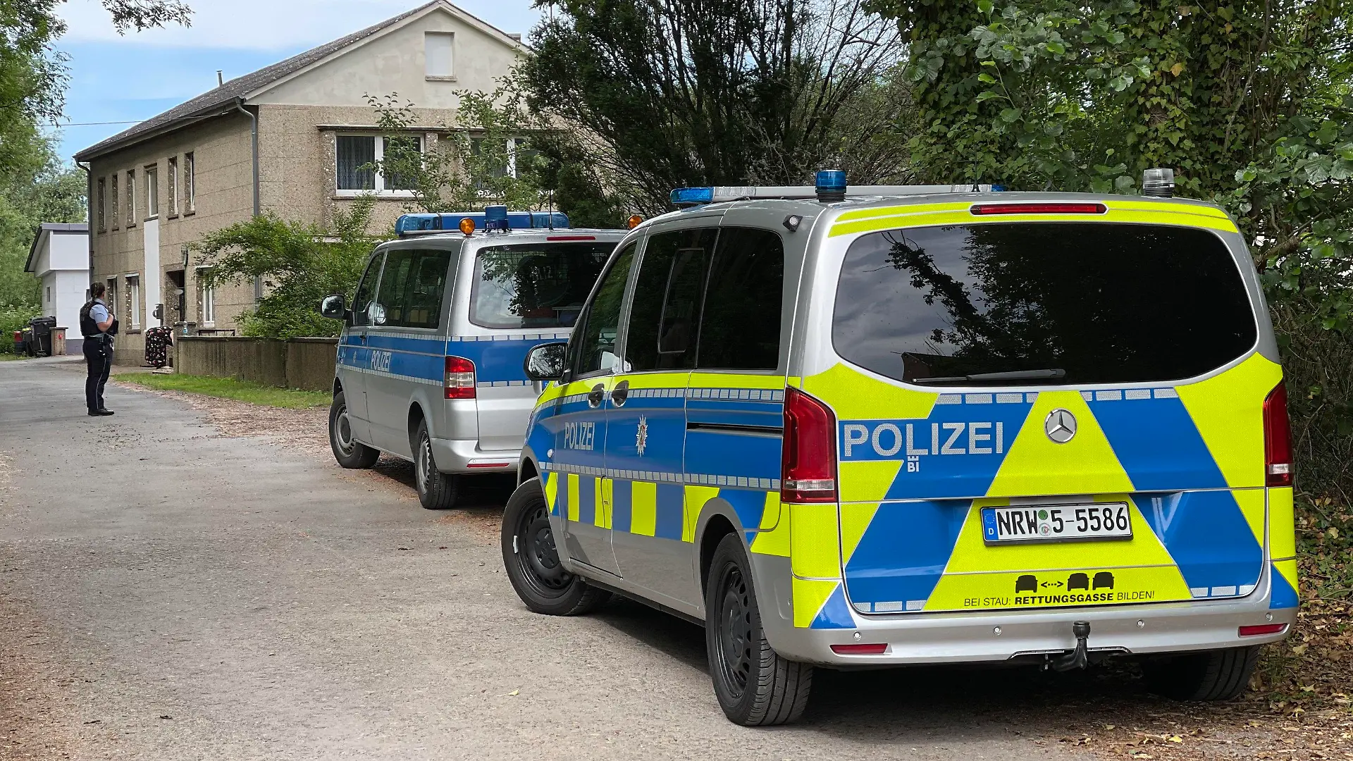 21.06.2022, Nordrhein-Westfalen, Kalletal: Polizeifahrzeuge stehen im Rahmen einer Grossfahndung auf einer Strasse in Kalletal. Bei der Fahndung nach einem 36-jährigen Mann im Kreis Lippe zieht die Polizei derzeit starke Kräfte in Kalletal zusammen. Nach Mitteilung der Polizei vom späten Dienstagnachmittag gehen die Ermittler einer Vielzahl von Hinweisen aus der Bevölkerung auf den Flüchtigen und seinen Aufenthaltsort im Ortsteil Stemmen nach. Ziel sei es, den Gesuchten zu finden und festzunehmen. Der Mann soll in der vergangenen Woche aus Eifersucht einen 39-Jährigen mit einer Axt getötet haben. Bei einer Verkehrskontrolle war er am Samstagmorgen zu Fuß geflüchtet. Seitdem wird nach ihm gefahndet. Foto: Christian Müller/dpa +++ dpa-Bildfunk +++