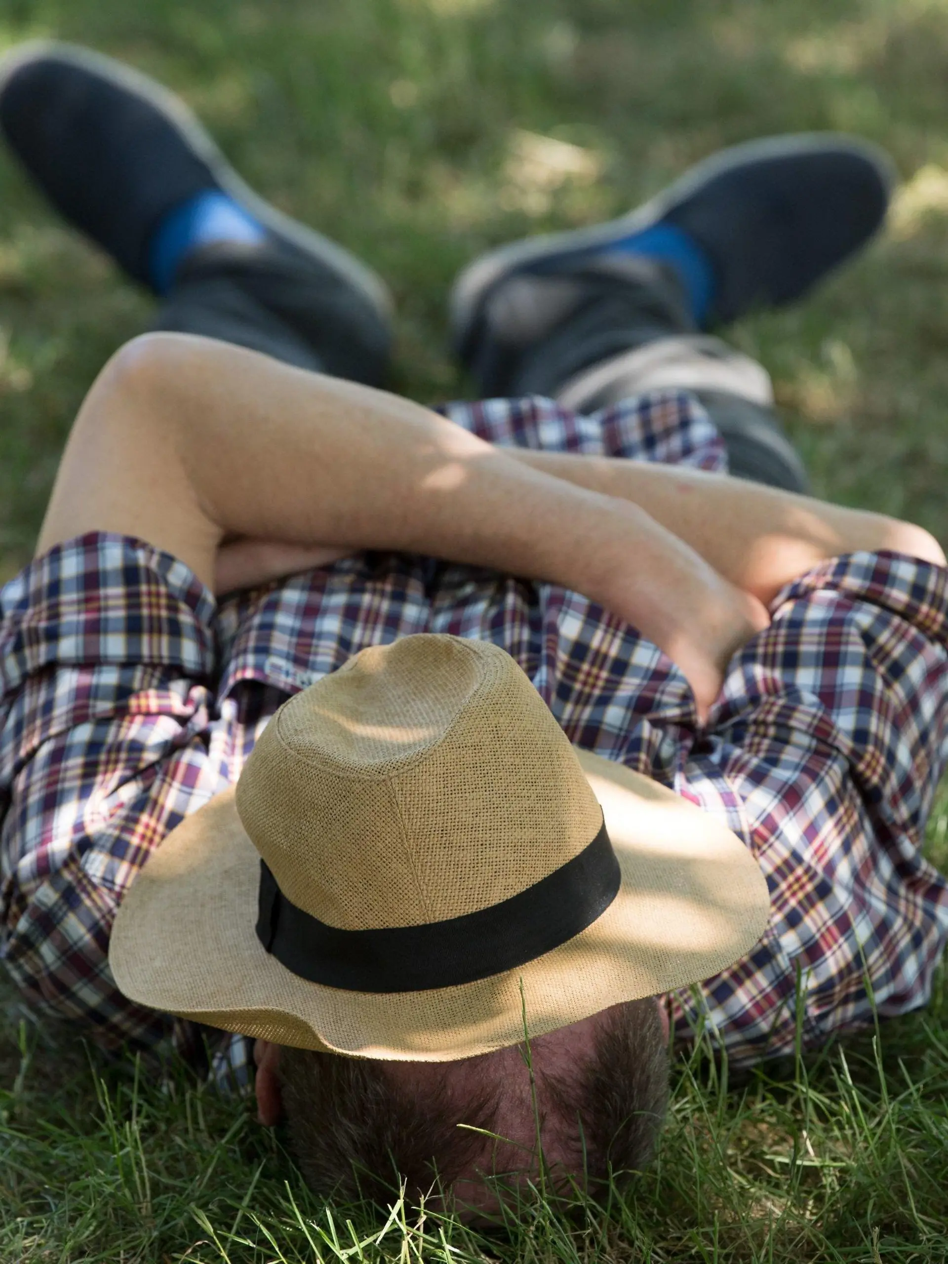 ARCHIV - 07.06.2018, Sachsen, Dresden: Ein Mann  mit einem Sonnenhut auf dem Gesicht  liegt auf einer Wiese im Schatten und ruht sich aus.   (zu dpa "DGB fordert wegen Hitze «Siesta» für Arbeitnehmer") Foto: Sebastian Kahnert/zb/dpa +++ dpa-Bildfunk +++