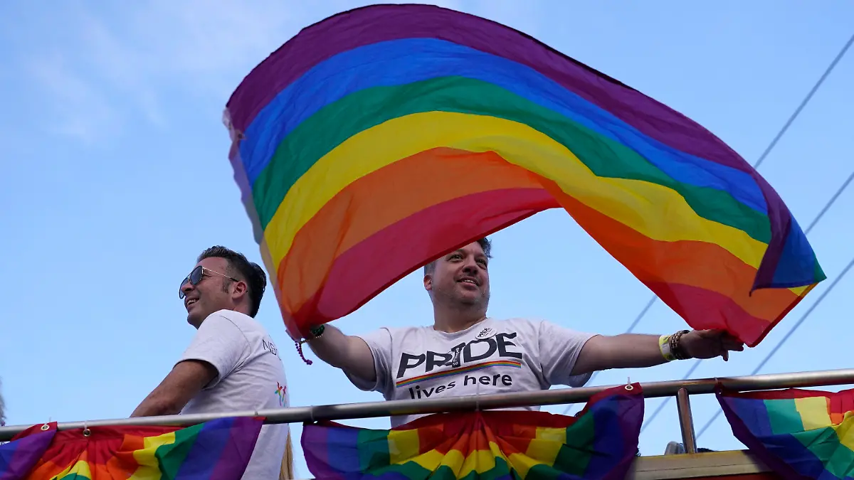A man waves a rainbow flag in the Stonewall Pride Parade, Saturday, June 18, 2022, during Pride Month in Wilton Manors, Fla. The annual parade celebrates the historic Stonewall riots and the start of the LGBTQ human rights movement. (AP Photo/Lynne Sladky)