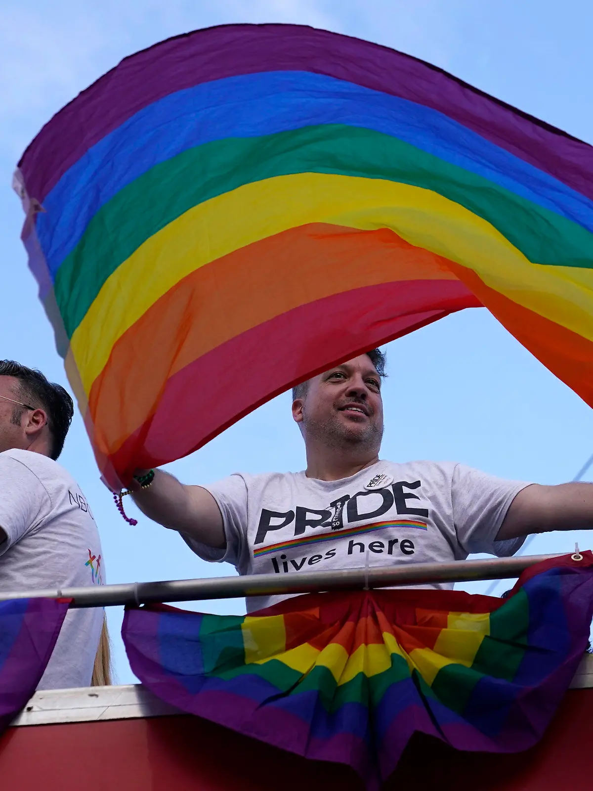 A man waves a rainbow flag in the Stonewall Pride Parade, Saturday, June 18, 2022, during Pride Month in Wilton Manors, Fla. The annual parade celebrates the historic Stonewall riots and the start of the LGBTQ human rights movement. (AP Photo/Lynne Sladky)