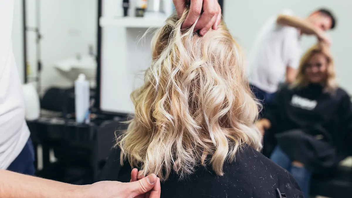 Friseur stylt Haare von Frau.
