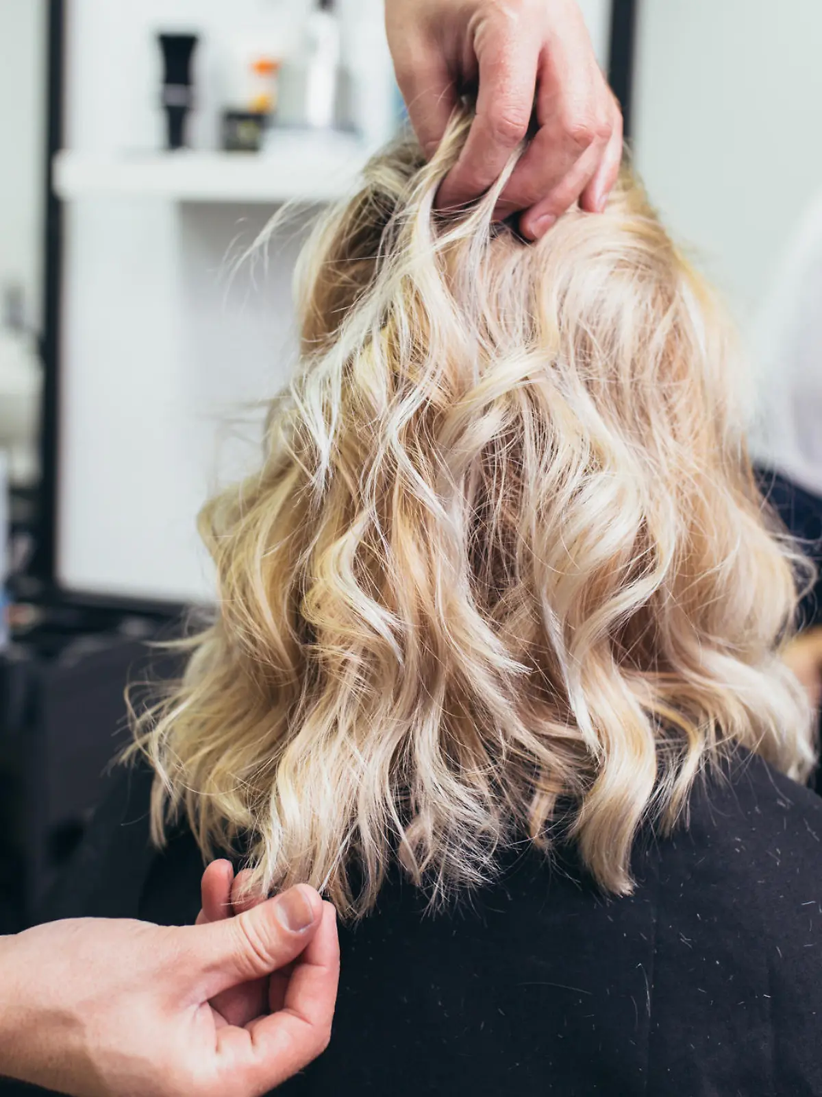 Friseur stylt Haare von Frau.