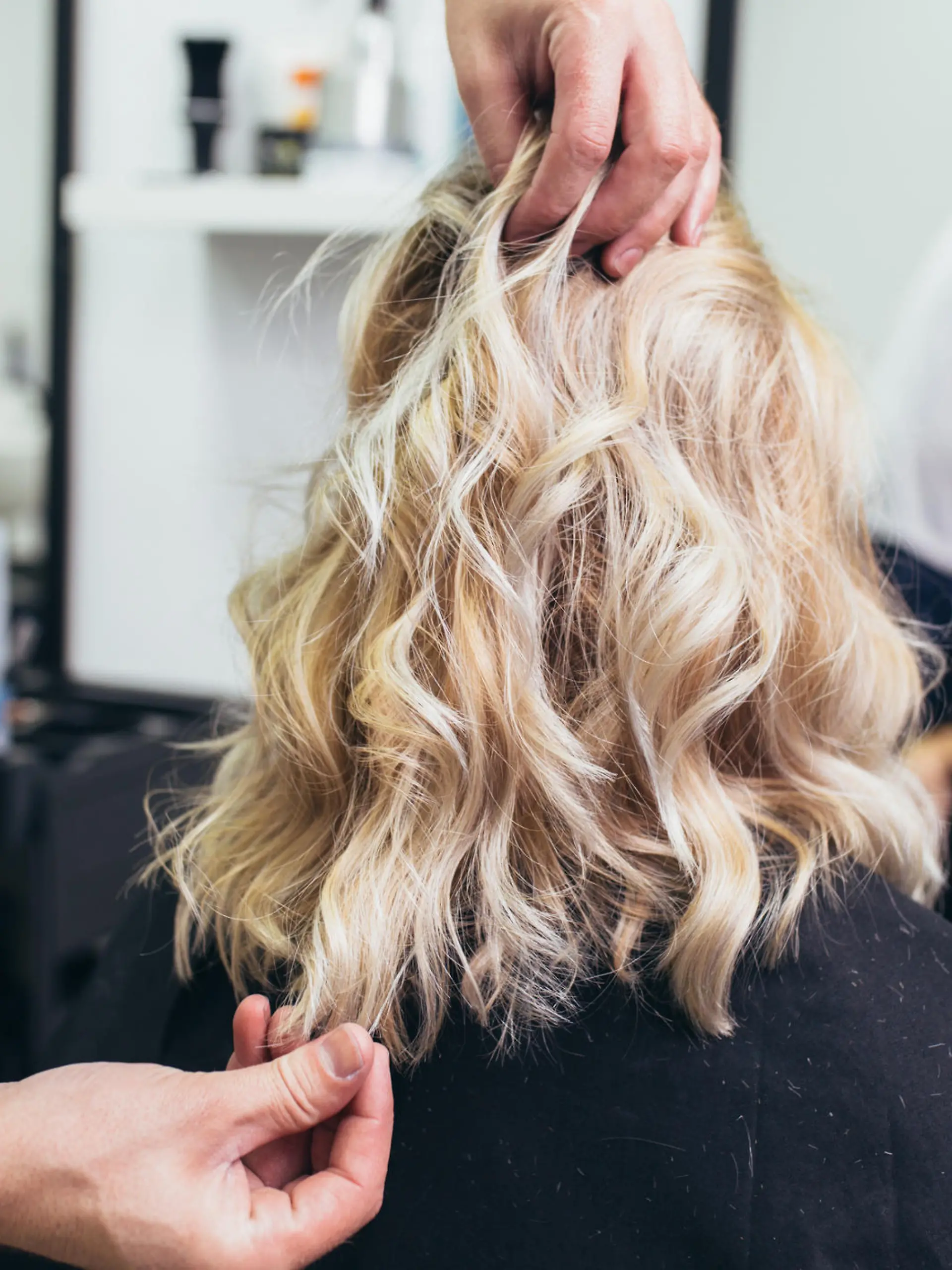 Friseur stylt Haare von Frau.