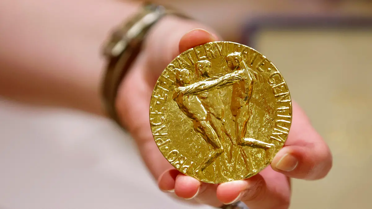 20.06.2022, USA, New York: Die 23-karätige Goldmedaille des russischen Journalisten Dmitri Muratow für den Friedensnobelpreis 2021 wird vor der Versteigerung im Times Center gezeigt. Der russische Journalist Dmitri Muratow lässt die Medaille seines Friedensnobelpreises zugunsten von Kriegsflüchtlingen aus der Ukraine versteigern. Foto: Eduardo Munoz Alvarez/AP/dpa +++ dpa-Bildfunk +++