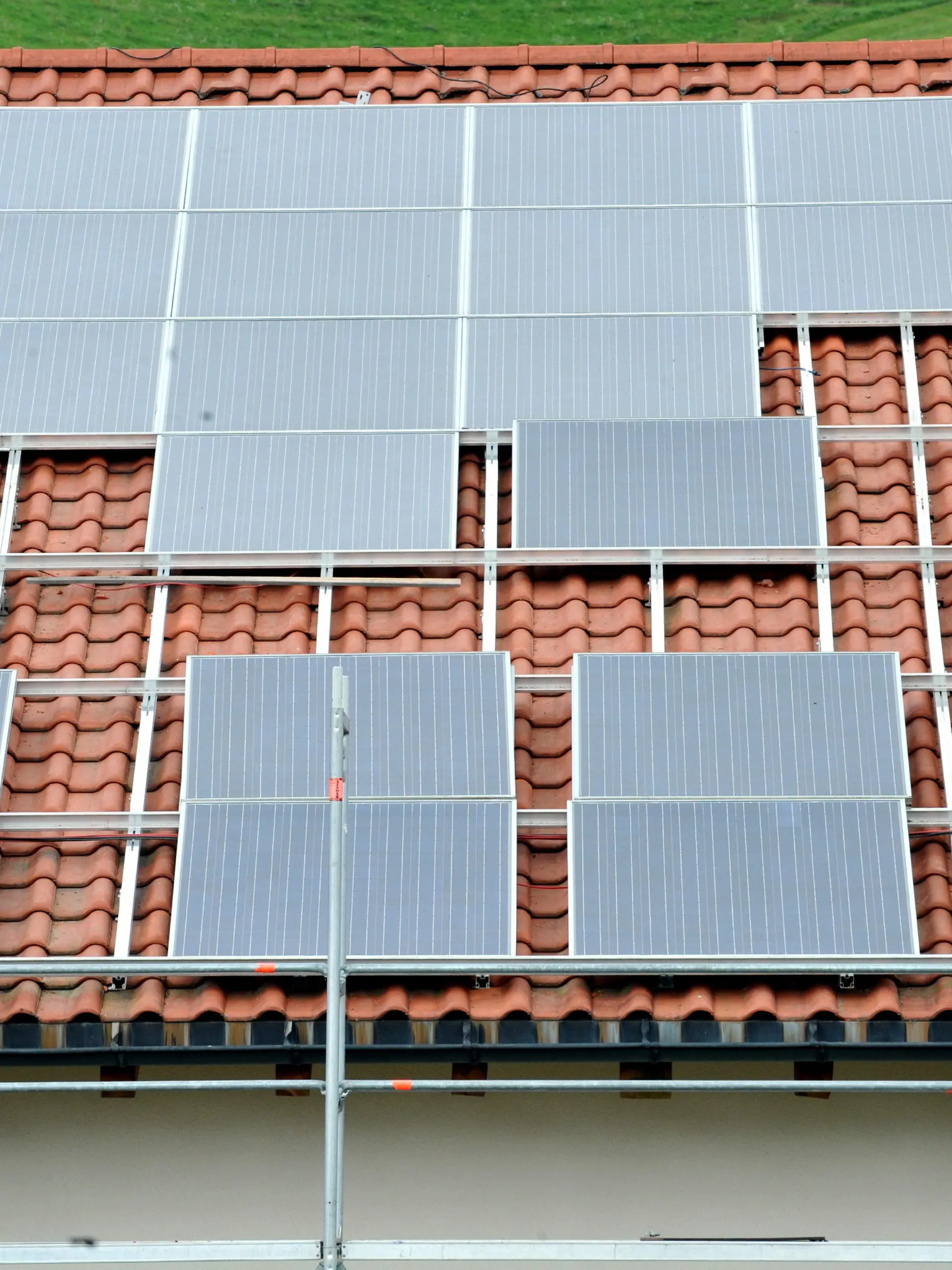ARCHIV - 11.08.2011, Baden-Württemberg, St.peter: Ein Arbeiter installiert auf einem Dach eine Solaranlage. Immer mehr Unternehmen und private Haushalte in Deutschland nutzen Sonnenenergie zur Stromerzeugung. (zu dpa «Immer mehr Solaranlagen auf deutschen Dächern») Foto: Rolf Haid/dpa +++ dpa-Bildfunk +++