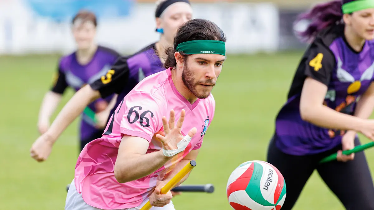 11.06.2022, Niedersachsen, Hannover: Robin Menzel von der Quidditch-Mannschaft "Broomicorns" (pink, Tura 1865 Braunschweig) in Aktion mit dem Quaffle (dt. Quaffel). Menzel ist deutscher Nationalspieler. Quidditch ist ein Kontaktsport, der in gemischtgeschlechtlichen Teams gespielt wird und Elemente aus verschiedenen Ballsportarten miteinander vereint. (zu dpa-Korr "Ballsport mit Besen: Wie Quidditch sich von Harry Potter löst") Foto: Michael Matthey/dpa +++ dpa-Bildfunk +++