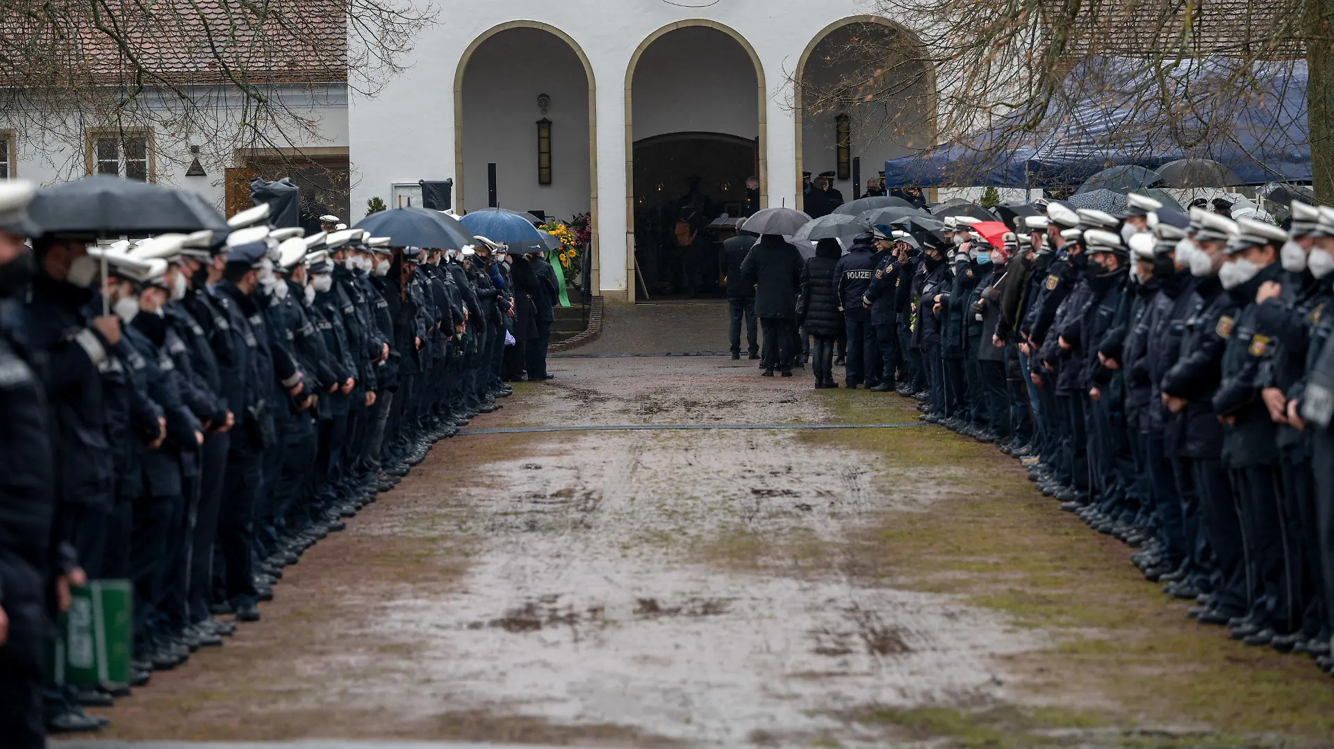 16.02.2022, Saarland, Homburg: Polizisten und Polizistinnen stehen an der Kirche Spalier beim Gedenkgottesdienst für eine getötete Polizistin. Nach der Bestattung eines ermordeten Polizisten wird nun auch seine getötete Kollegin beigesetzt. Der 29 Jahre alte Polizeikommissar und die 24 Jahre alte Polizeianwärterin waren am 31. Januar während einer Fahrzeugkontrolle bei Kusel erschossen worden. Foto: Harald Tittel/dpa +++ dpa-Bildfunk +++