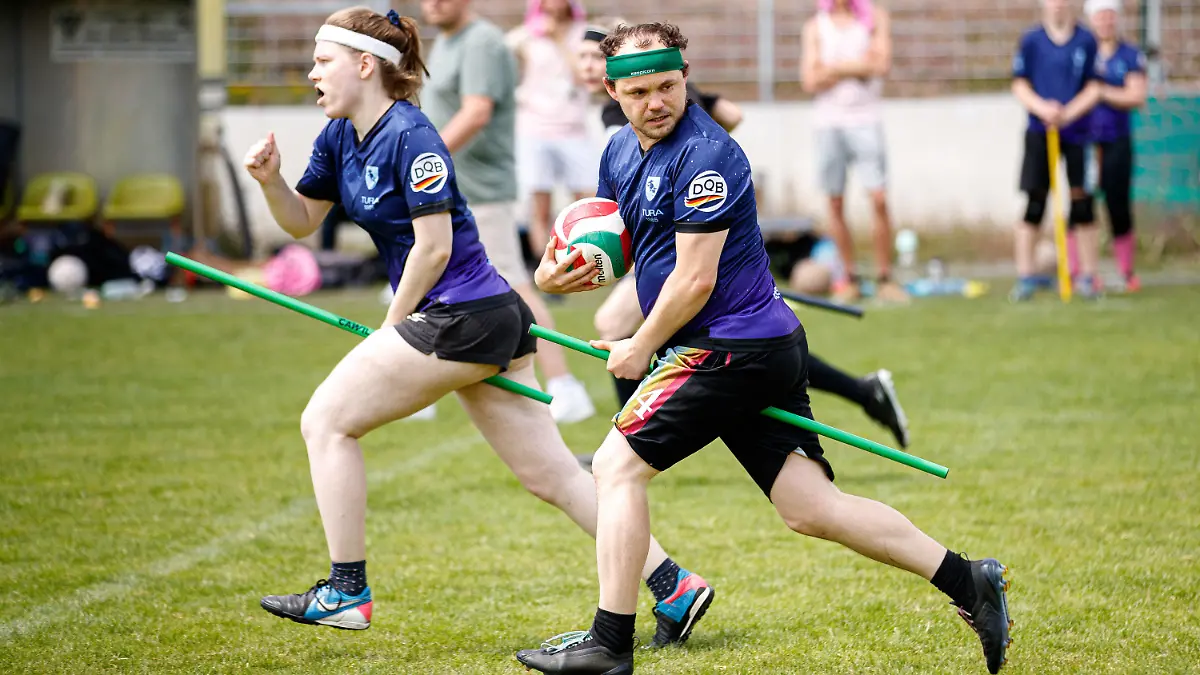 11.06.2022, Niedersachsen, Hannover: Spieler der "Bröwicorns" (blau, Tura 1865 Braunschweig) in Aktion auf dem Spielfeld. Quidditch ist ein Kontaktsport, der in gemischtgeschlechtlichen Teams gespielt wird und Elemente aus verschiedenen Ballsportarten miteinander vereint. (zu dpa-Korr "Ballsport mit Besen: Wie Quidditch sich von Harry Potter löst") Foto: Michael Matthey/dpa +++ dpa-Bildfunk +++