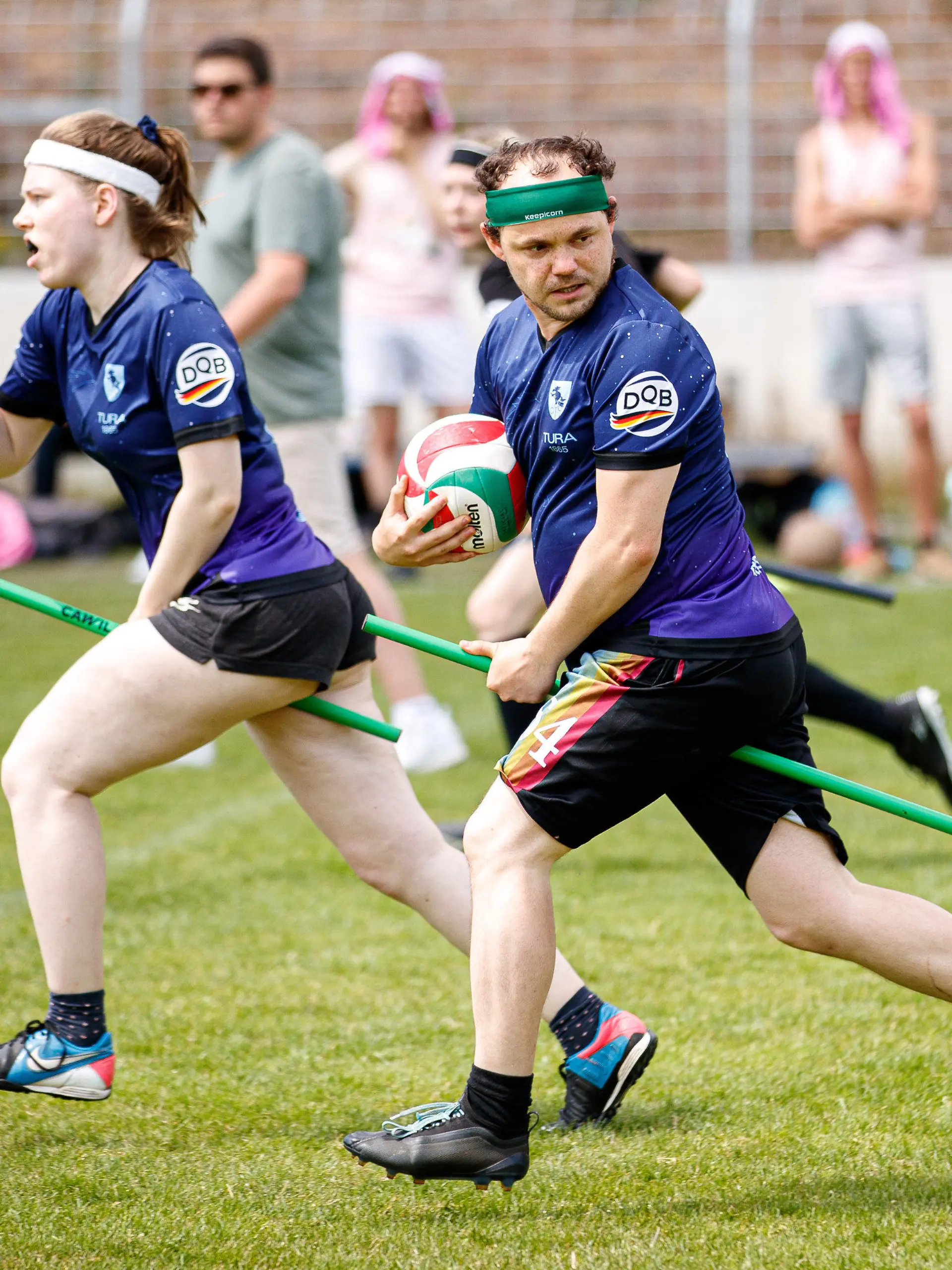 11.06.2022, Niedersachsen, Hannover: Spieler der "Bröwicorns" (blau, Tura 1865 Braunschweig) in Aktion auf dem Spielfeld. Quidditch ist ein Kontaktsport, der in gemischtgeschlechtlichen Teams gespielt wird und Elemente aus verschiedenen Ballsportarten miteinander vereint. (zu dpa-Korr "Ballsport mit Besen: Wie Quidditch sich von Harry Potter löst") Foto: Michael Matthey/dpa +++ dpa-Bildfunk +++