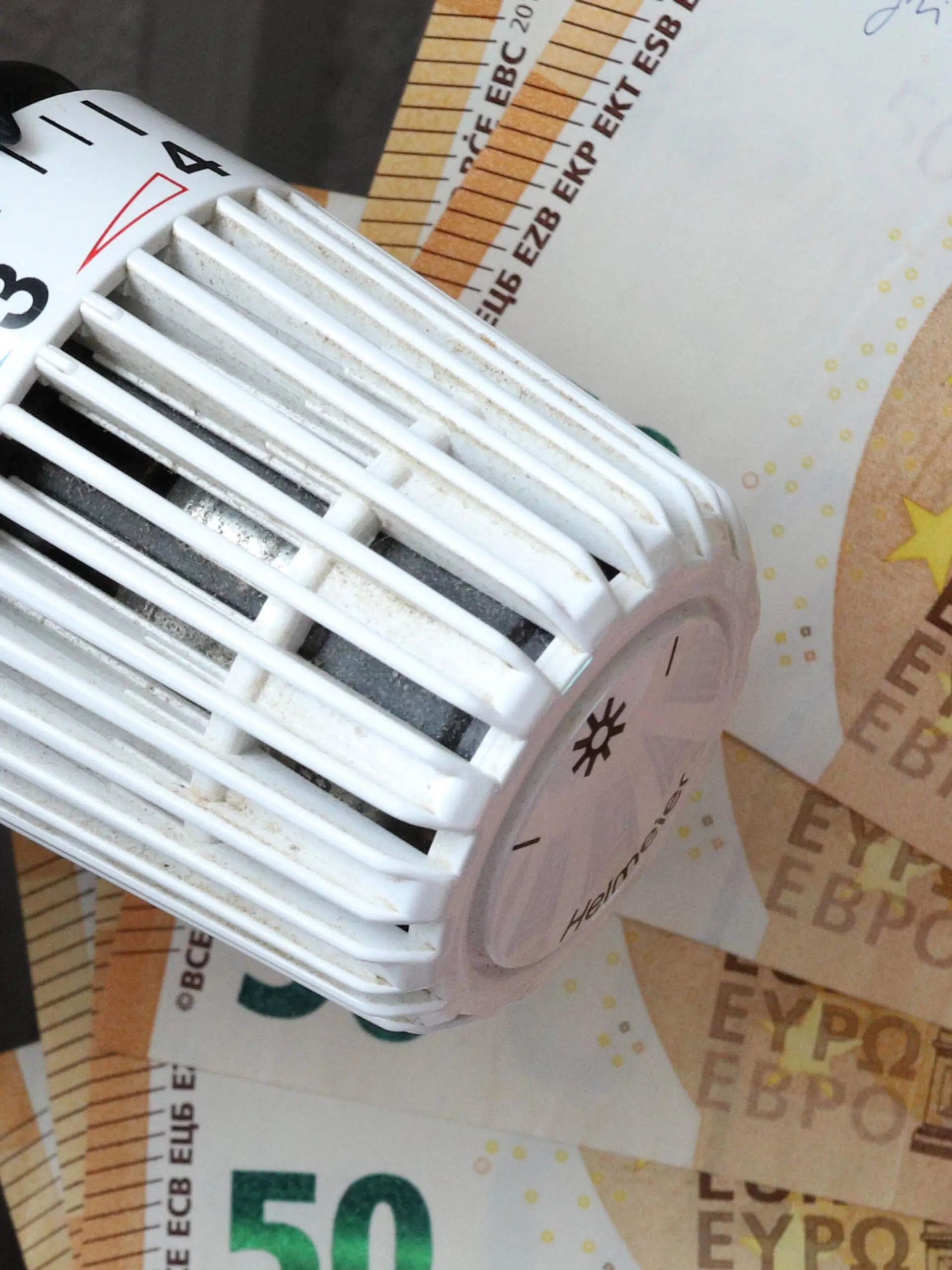 Steigende Inflation - Symbolbilder Die Energiekosten steigen und steigen, Thermostatkopf an einem Heizkoerper mit Geld, Geldscheinen, Euroscheinen Symbolbild zum Thema Energiekosten am 16.10.2021 in Siegen/Deutschland *** The energy costs rise and rise, thermostat head on a radiator with money, banknotes, euro notes symbol picture on the subject of energy costs on 16 10 2021 in Siegen Germany