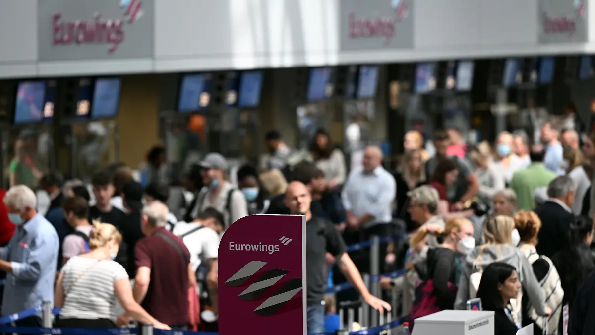 21.06.2022, Nordrhein-Westfalen, Düsseldorf: Zahlreiche Passagiere stehen an den Eurowings-Schaltern im Flughafen Düsseldorf. Wegen Personalproblemen hat die Airline Eurowings erneut zahlreiche Verbindungen an den beiden größten Flughäfen Nordrhein-Westfalens gestrichen. Betroffen waren zum Beispiel Flüge nach Berlin, Budapest, Wien und Nizza. Foto: Federico Gambarini/dpa +++ dpa-Bildfunk +++