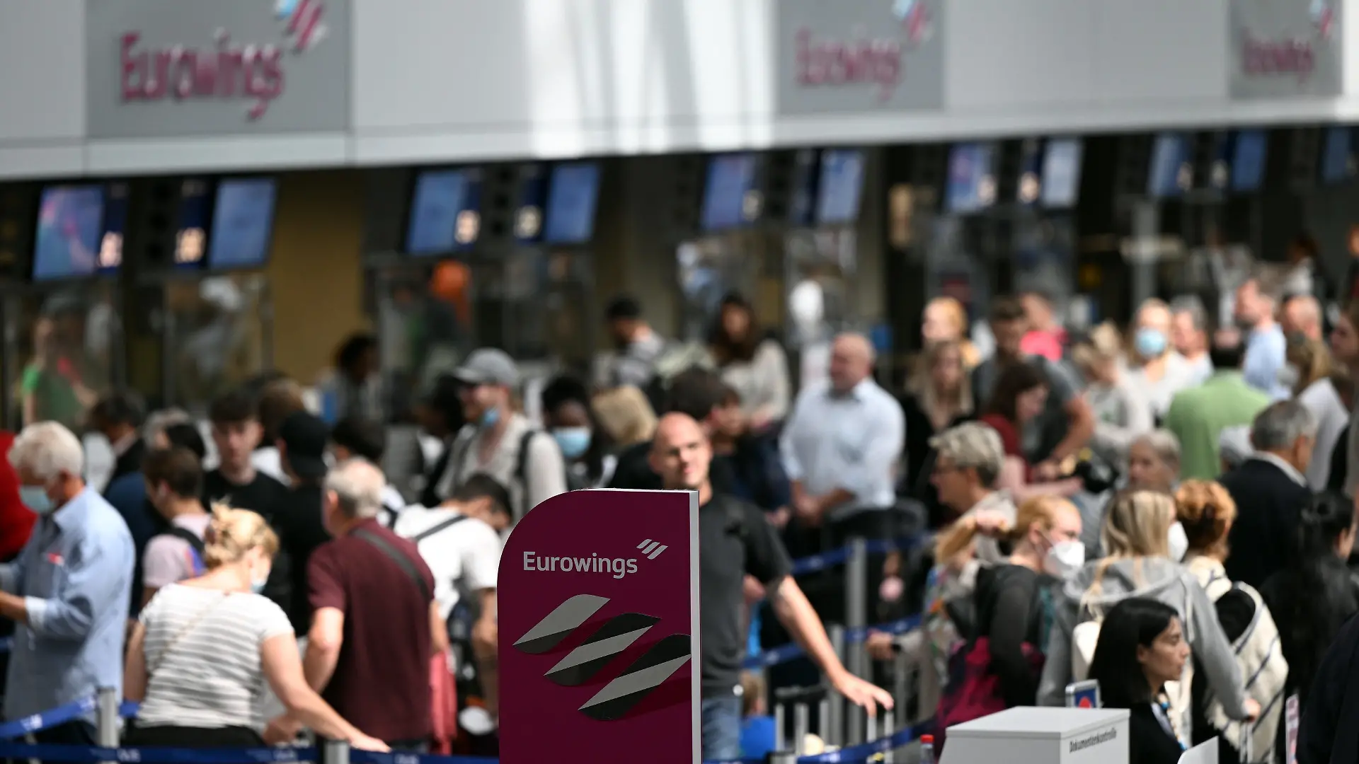 21.06.2022, Nordrhein-Westfalen, Düsseldorf: Zahlreiche Passagiere stehen an den Eurowings-Schaltern im Flughafen Düsseldorf. Wegen Personalproblemen hat die Airline Eurowings erneut zahlreiche Verbindungen an den beiden größten Flughäfen Nordrhein-Westfalens gestrichen. Betroffen waren zum Beispiel Flüge nach Berlin, Budapest, Wien und Nizza. Foto: Federico Gambarini/dpa +++ dpa-Bildfunk +++