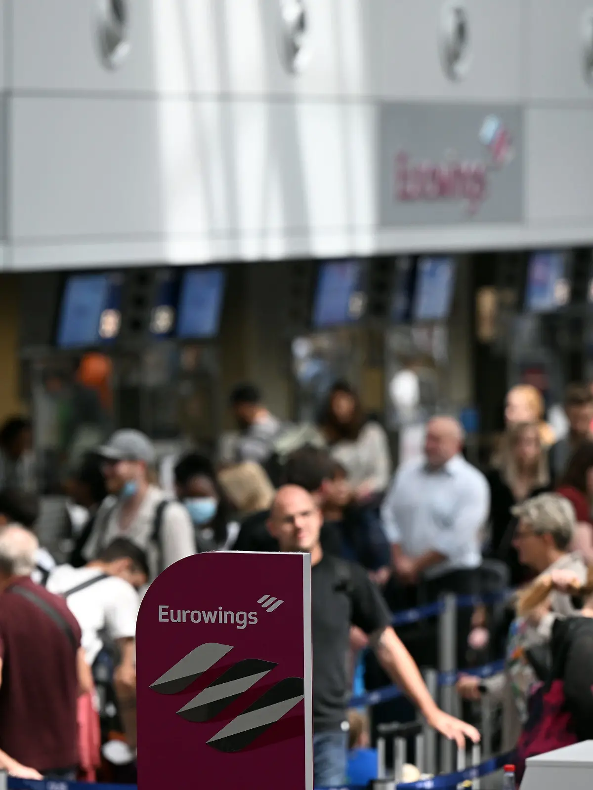 21.06.2022, Nordrhein-Westfalen, Düsseldorf: Zahlreiche Passagiere stehen an den Eurowings-Schaltern im Flughafen Düsseldorf. Wegen Personalproblemen hat die Airline Eurowings erneut zahlreiche Verbindungen an den beiden größten Flughäfen Nordrhein-Westfalens gestrichen. Betroffen waren zum Beispiel Flüge nach Berlin, Budapest, Wien und Nizza. Foto: Federico Gambarini/dpa +++ dpa-Bildfunk +++