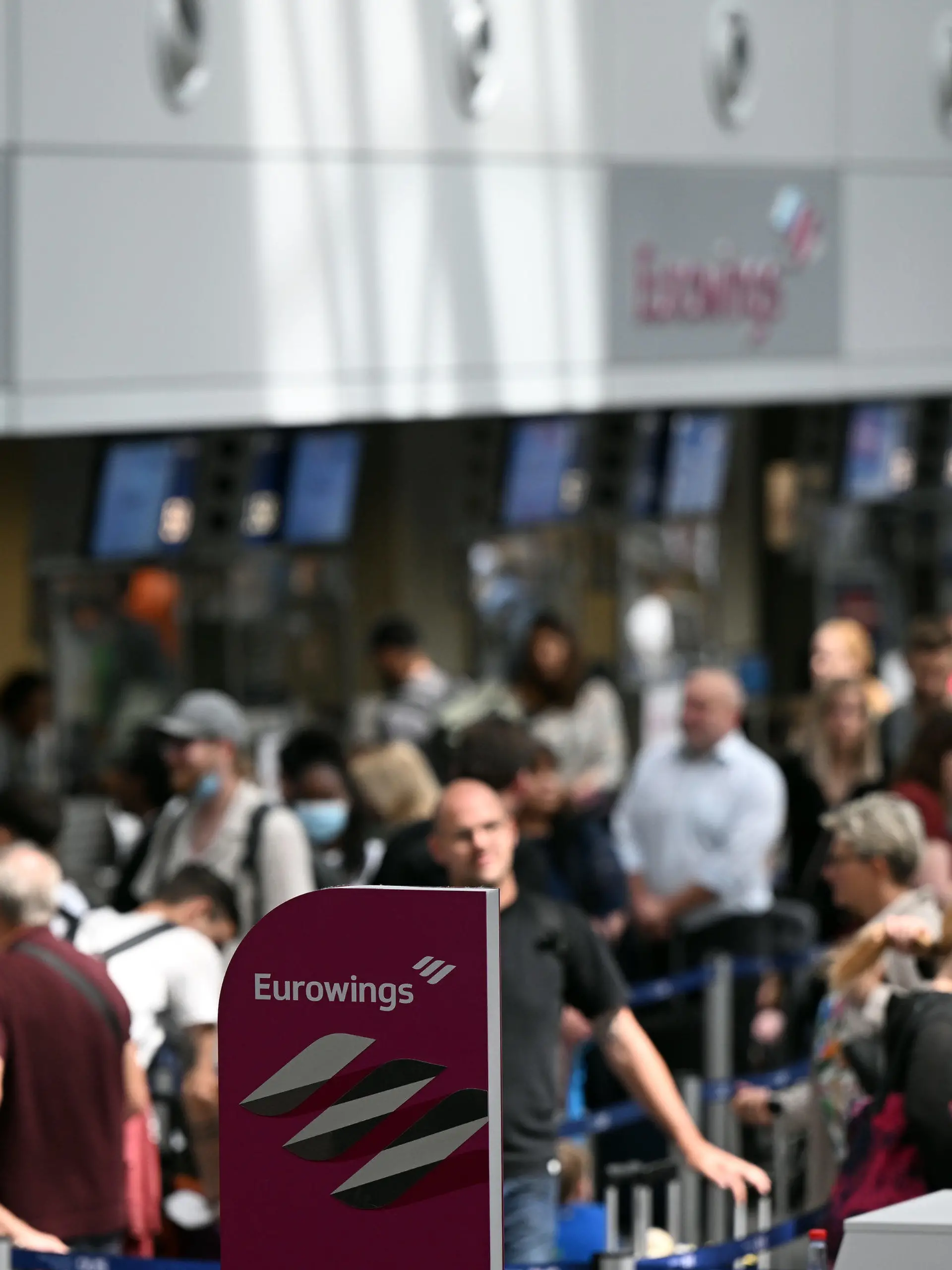 21.06.2022, Nordrhein-Westfalen, Düsseldorf: Zahlreiche Passagiere stehen an den Eurowings-Schaltern im Flughafen Düsseldorf. Wegen Personalproblemen hat die Airline Eurowings erneut zahlreiche Verbindungen an den beiden größten Flughäfen Nordrhein-Westfalens gestrichen. Betroffen waren zum Beispiel Flüge nach Berlin, Budapest, Wien und Nizza. Foto: Federico Gambarini/dpa +++ dpa-Bildfunk +++