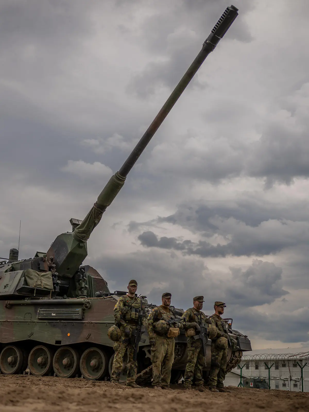 07.06.2022, Litauen, Pabrade: Soldaten stehen vor einem gepanzerten, selbstfahrenden Artilleriegeschütz vom Typ Panzerhaubitze 2000 der Bundeswehr, das von der NATO Enhanced Forward Presence Battle Group (eFP-Bataillon) eingesetzt wird, während des Besuchs von Bundeskanzler Scholz im Camp Adrian Rohn. Scholz hat Litauen zusätzliche militärische Unterstützung für die Verteidigung gegen einen möglichen russischen Angriff zugesagt. Foto: Michael Kappeler/dpa +++ dpa-Bildfunk +++
