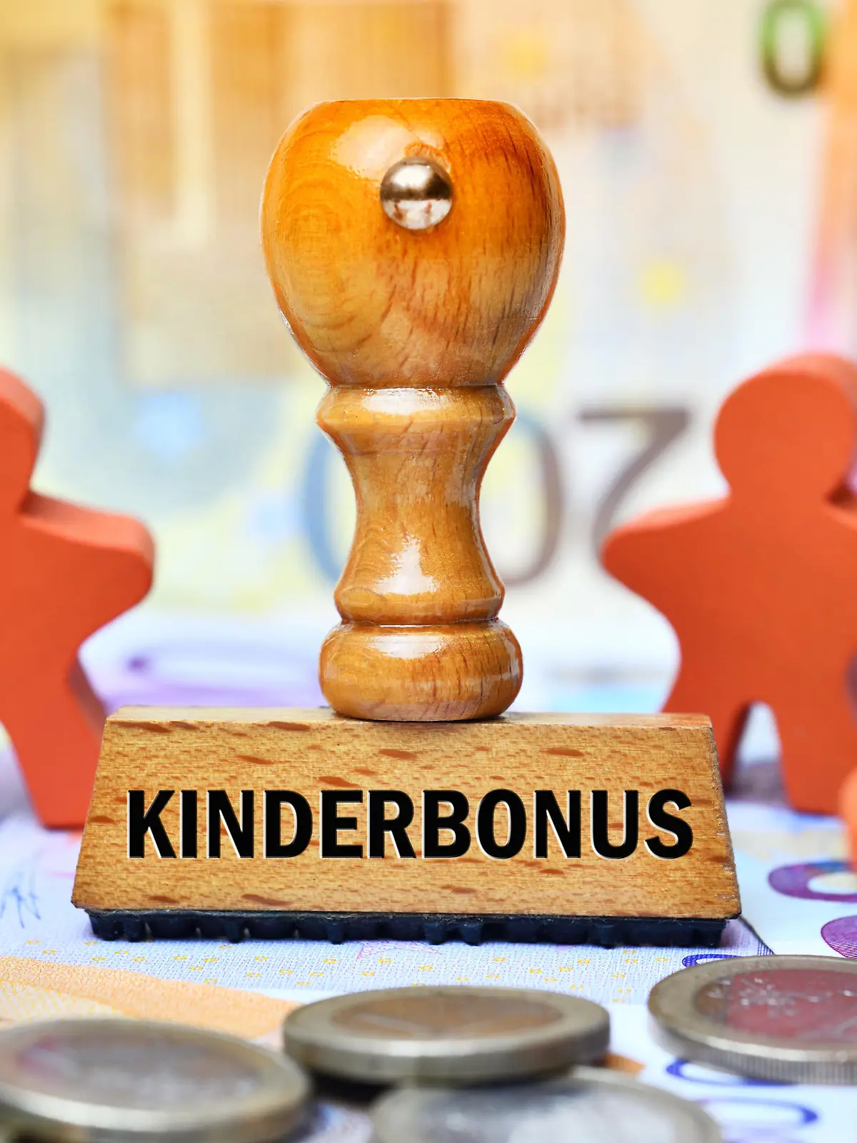 FOTOMONTAGE, Stempel mit Aufschrift Kinderbonus und Kinderfiguren auf Geldscheinen