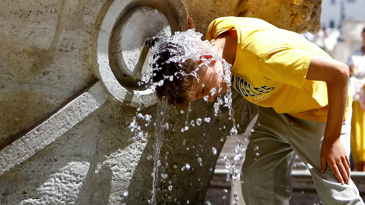 FILE PHOTO: A boy cools off at Fontana della Barcaccia at the Spanish Steps during a heat wave across Italy as temperatures are expected to rise further in the coming days, in Rome, Italy July 17, 2023. REUTERS/Guglielmo Mangiapane TPX IMAGES OF THE DAY/File Photo