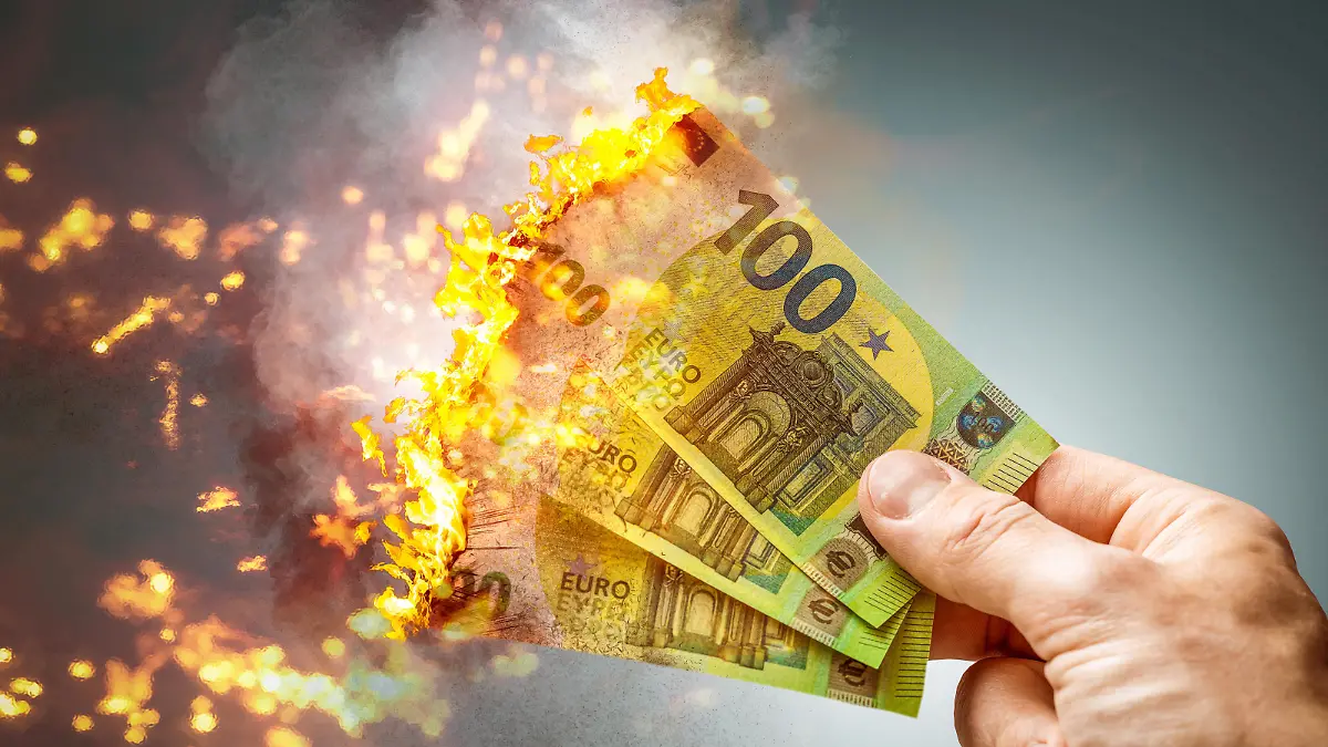 fire burning 100 euro banknotes, losing money, recession and inflation concept PHOTOMONTAGE
