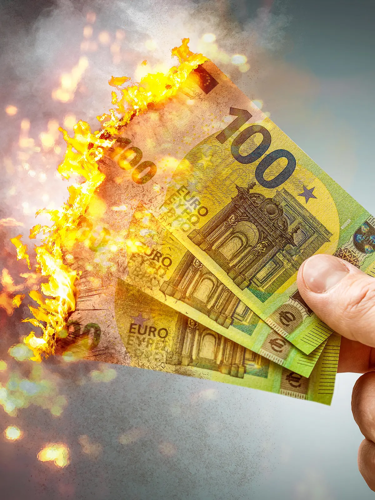 fire burning 100 euro banknotes, losing money, recession and inflation concept PHOTOMONTAGE