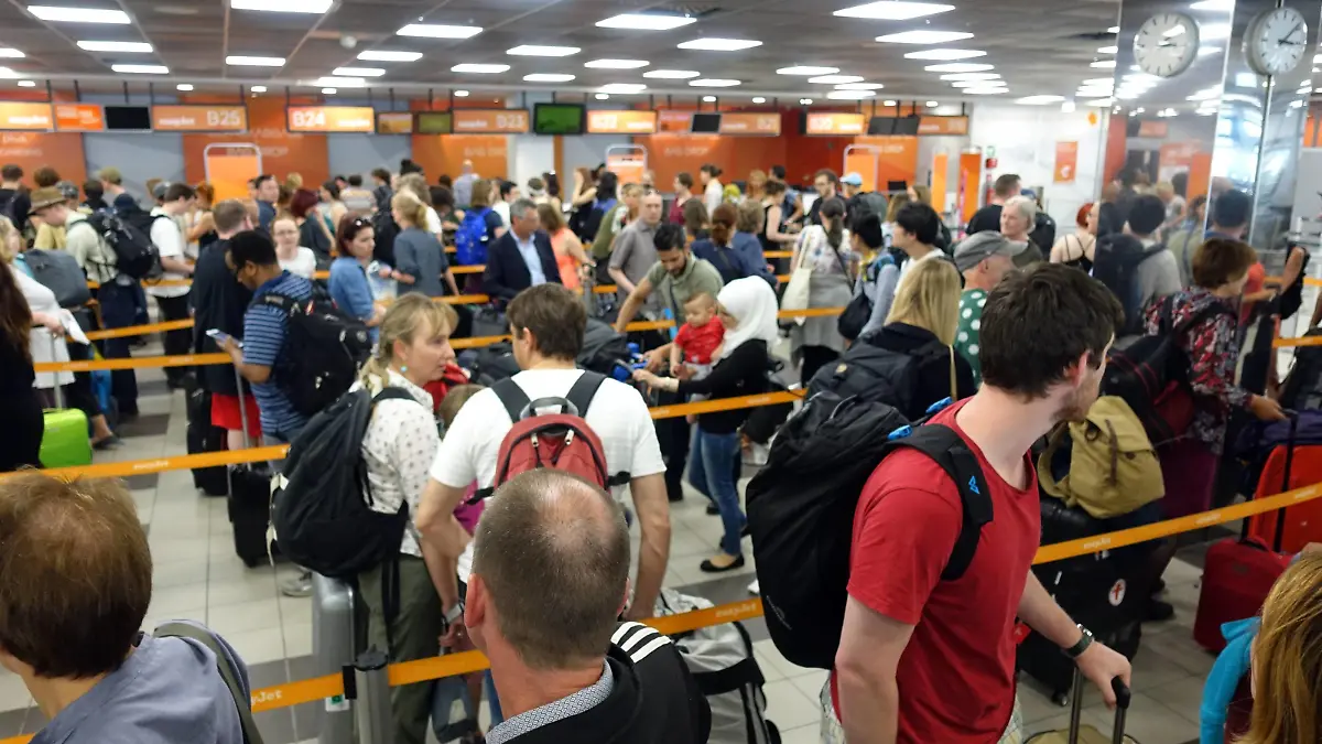 23.05.2017, Berlin, GER - Flugpassagiere stehen am Check-in von easyJet am Flughafen Berlin-Schoenefeld an. (abfertigen, Abfertigung, Abfertigungshalle, Abfertigungsschalter, Abflughalle, Alltag, anstehen, Berlin, Berlin-Schoenefeld, Berlin-Schönefeld, Betrieb, Billigflieger, Billigfluggesellschaft, Check in, Check-In, Check-in, Check-in-Schalter, deutsch, Deutschland, Dienstleistung, easy Jet, easyJet, einchecken, Europa, europaeisch, europäisch, Ferien, Fernreise, Fliegen, Flugbetrieb, Fluggaeste, Fluggesellschaft, Fluggäste, Flughafen, Flughafenpersonal, Fluglinie, Flugpassagiere, Flugreise, Flugverkehr, Gepaeckaufgabe, Gepäckaufgabe, Gesellschaft, innen, Innenaufnahme, Kaukasier, kaukasisch, Kofferaufgabe, Luftfahrt, Luftfahrtgesellschaft, Luftfahrtunternehmen, Luftverkehr, Menschen, Menschenmenge, Passagiere, Personal, Personen,